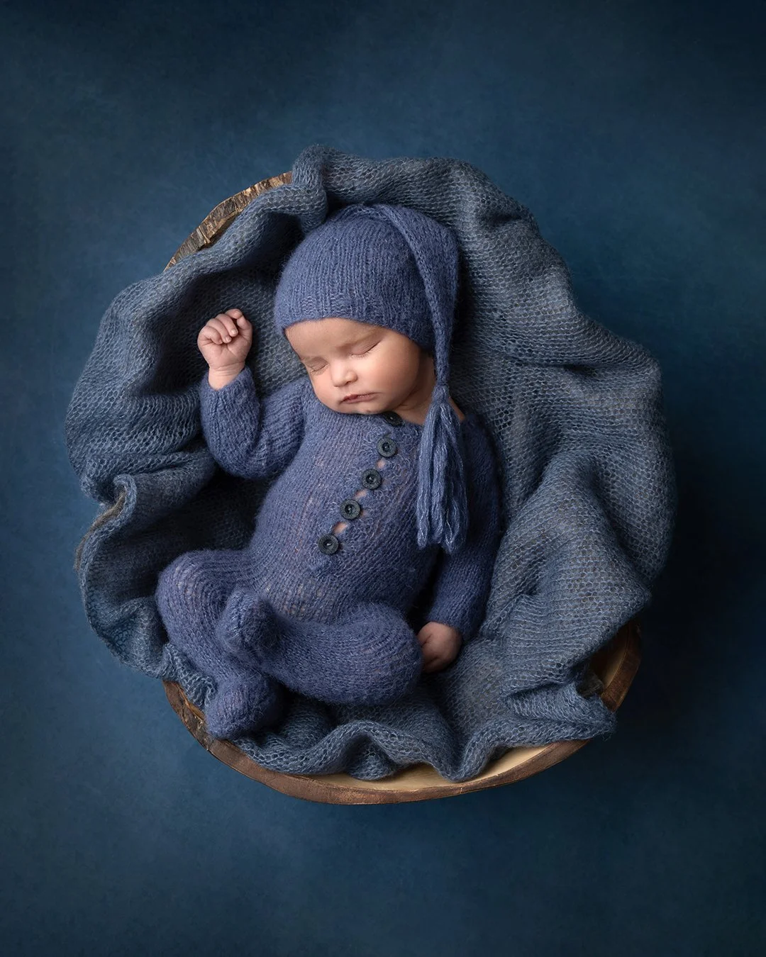 a portrait of a newborn baby with a sleepy cap posed in a circle prop