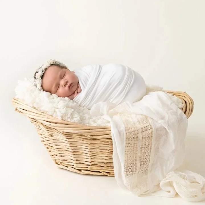 Newborn baby swaddled in a basket