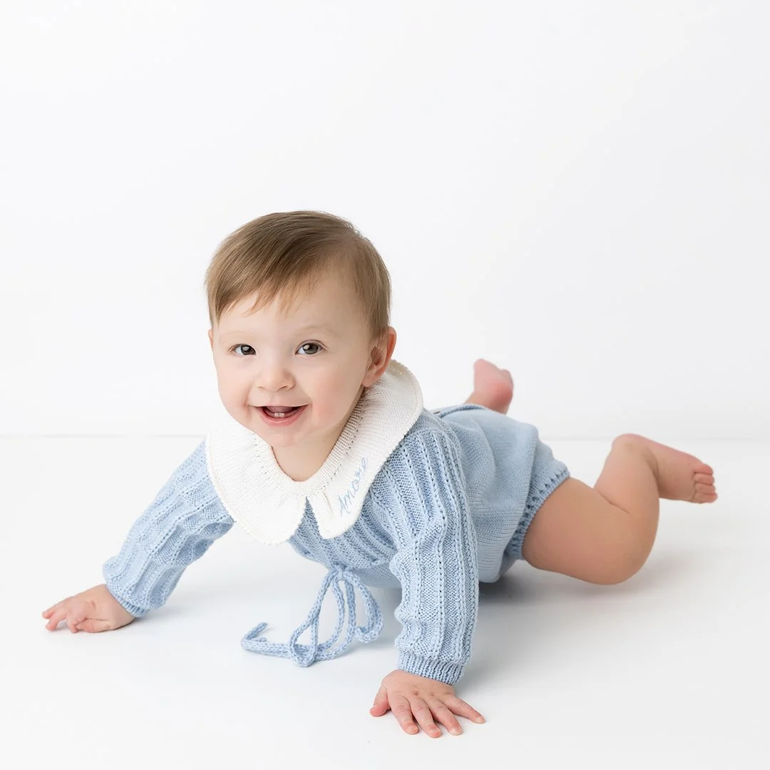 baby in blue sweater outfit crawling
