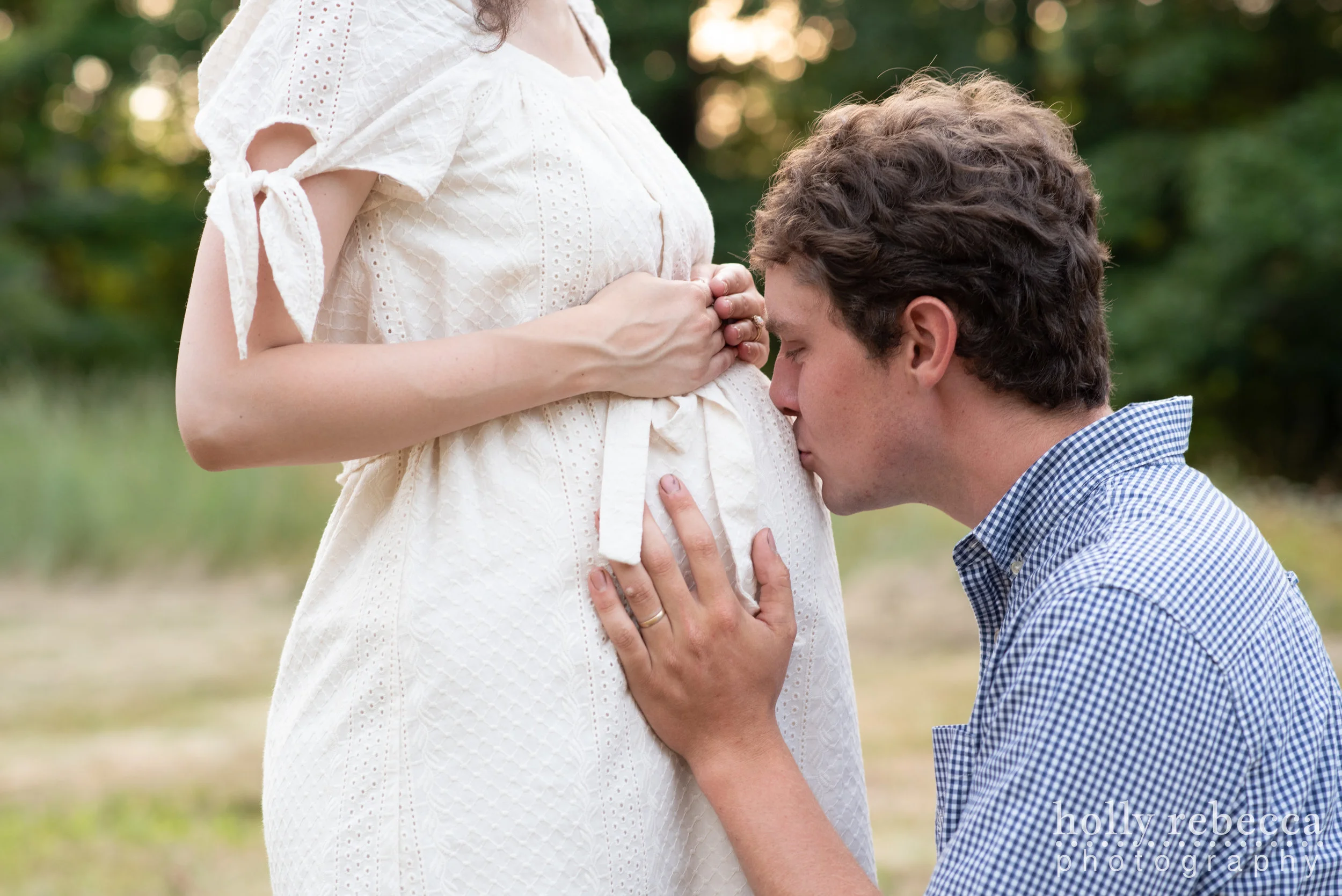 Husband kissing belly of pregnant wife