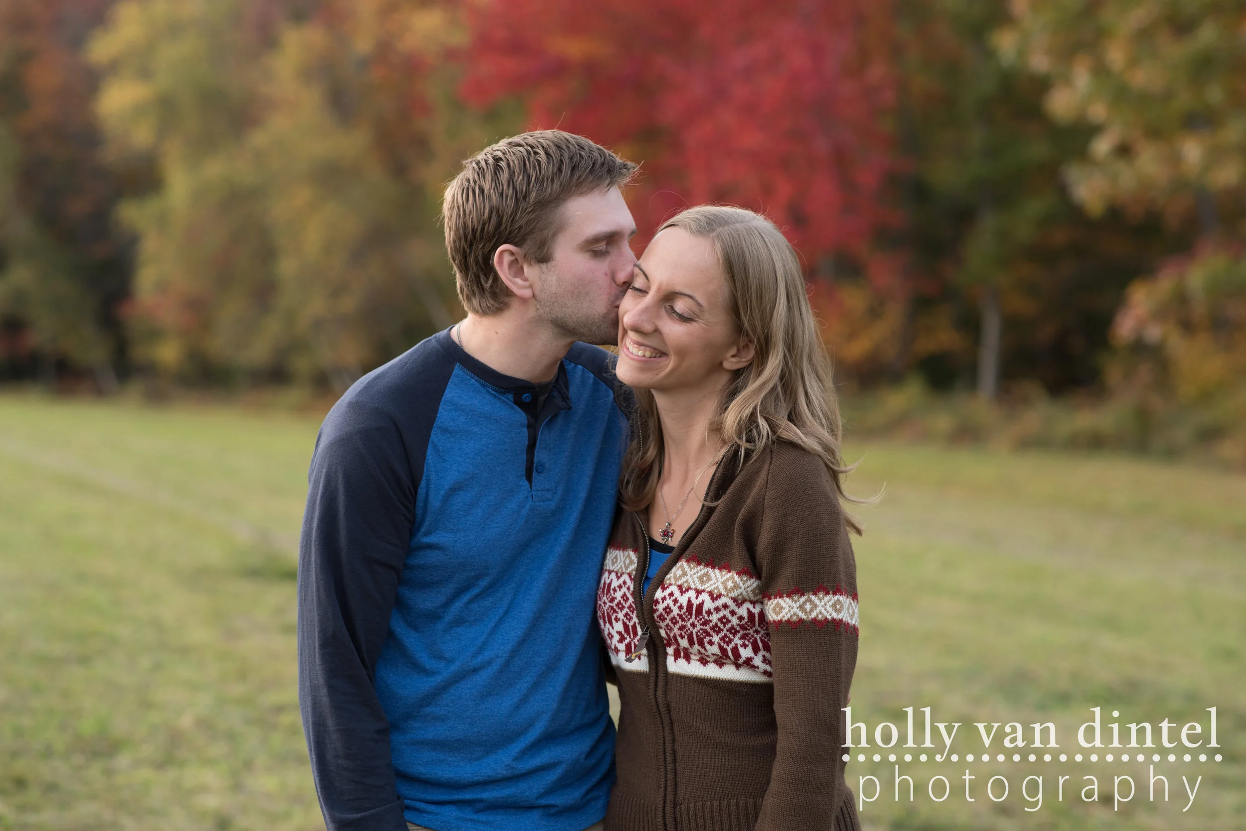 Engaged couple kiss on the cheek