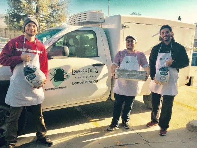 Loaves & Fishes’ team (Evan, Marco and Randy) load the truck todeliver turkeys and meals to our partners.