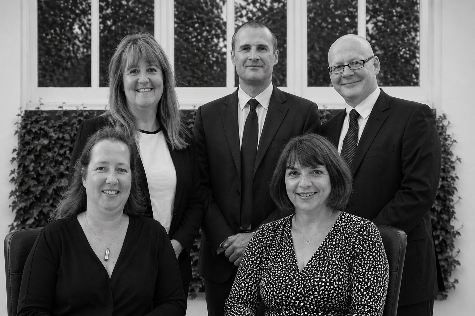 Wilson Bramwell Solicitors team group portrait in black and white at the Harrogate office, showing five staff members in professional business attire.