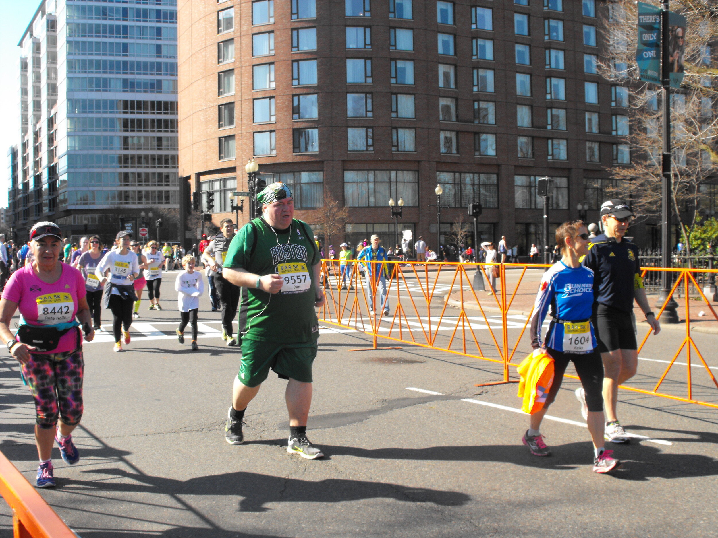  Boston. April 19, 2015. Turning the corner to finish the last few hundred yards of the BAA 5k, the third wave of runners make their way through towards the finish line; people from all walks of life, couples, parents and their young children, everyo