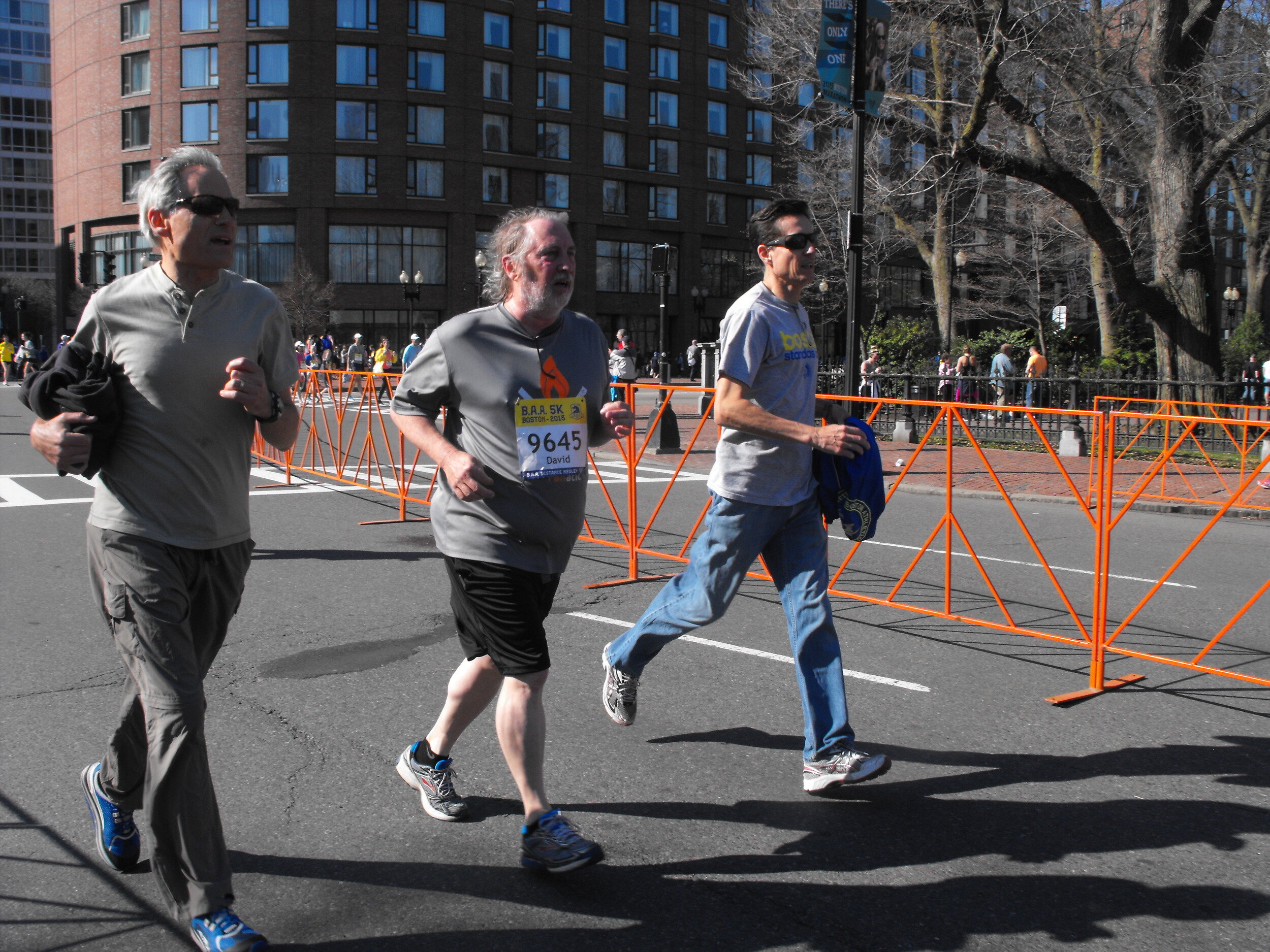  Boston. April 18, 2015. The true picture of life transitions - while the two men on either side of David don’t have their name and registration tags, they help their friend cross that finish line together to the end. (Photo by: Gina Kim/BU News Serv