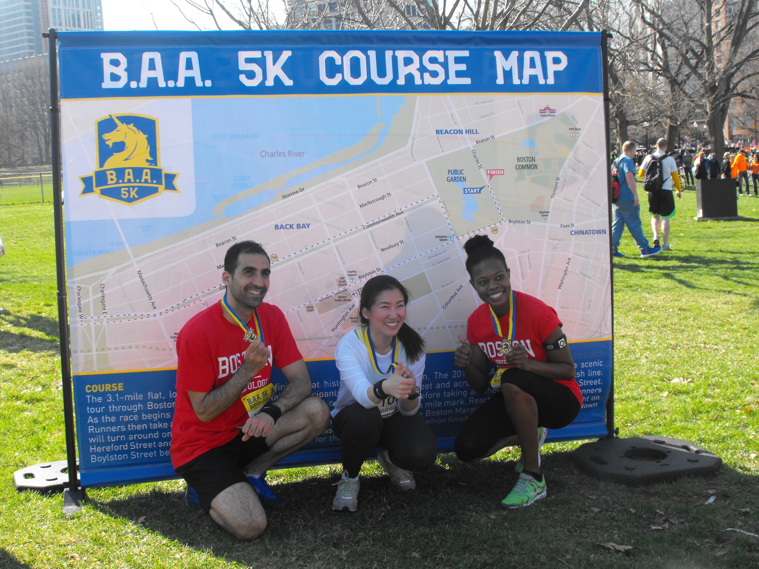  Boston. April 18, 2015. Three finishers of the BAA 5k pose with their medals in front of the racecourse map, two of whom are Boston University students; a proud accomplishment for these runners. (Photo by: Gina Kim/BU News Service) 