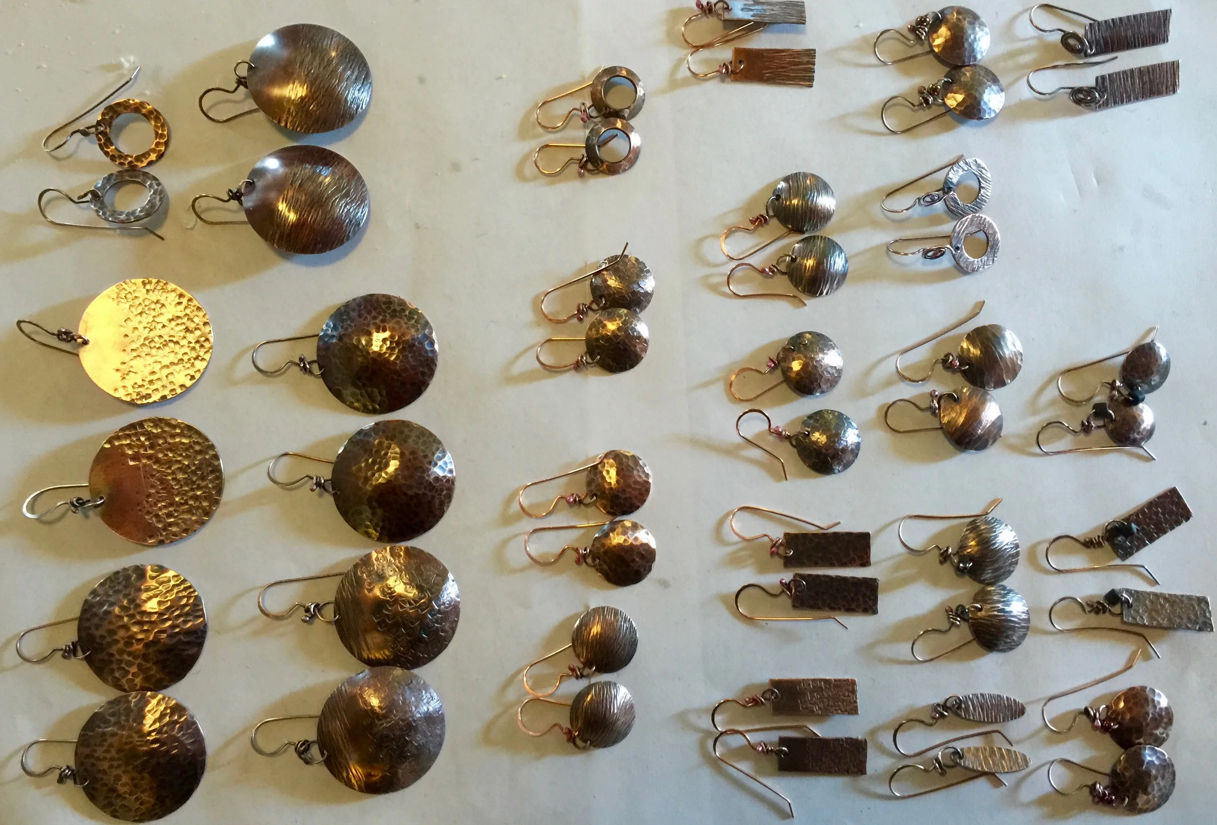A set of simple copper and brass earrings ready for carding. My hand forged ear wires enhance the simple forms.