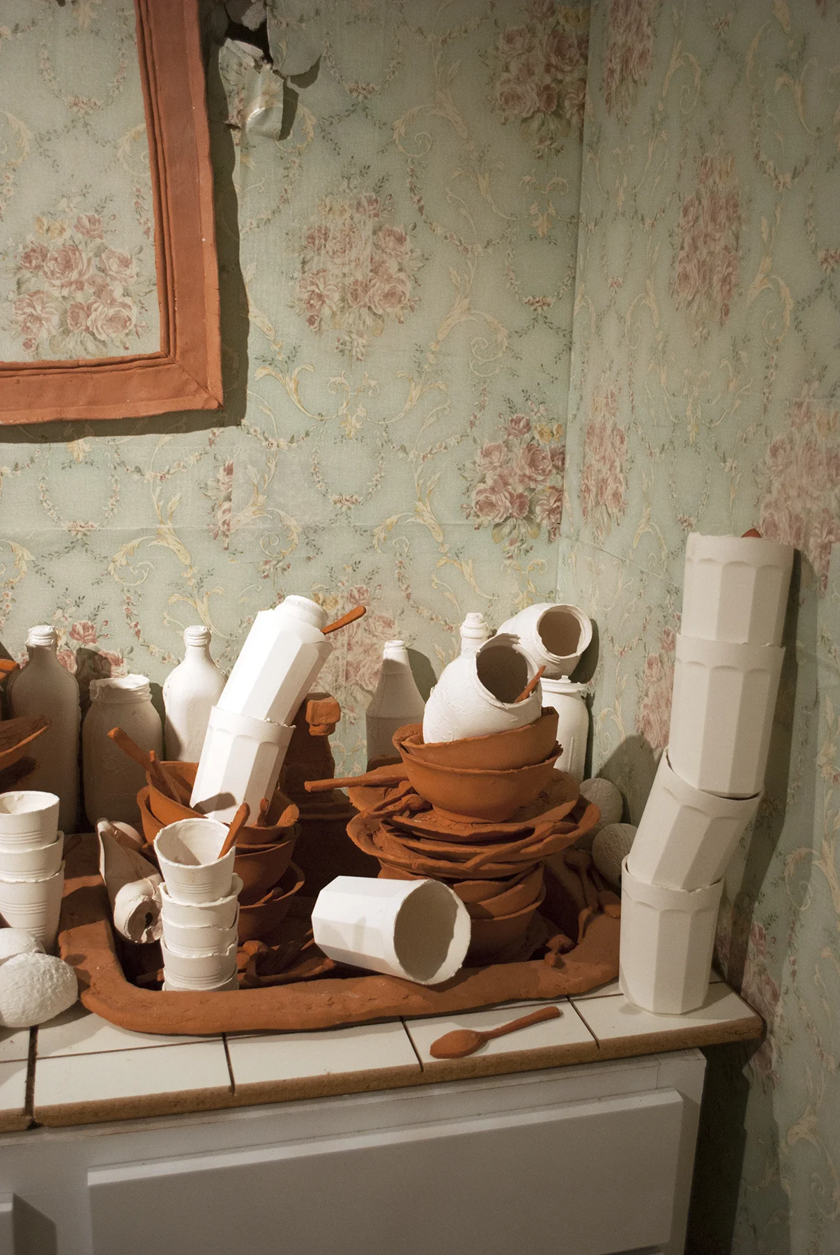 Terracotta, slip cast porcelain, found unfired cheese burger, carpet, metal, found cabinet, wallpaper, drywall, wood, latex Installation of life sized objects in 6’x12’x8’ room. 2018