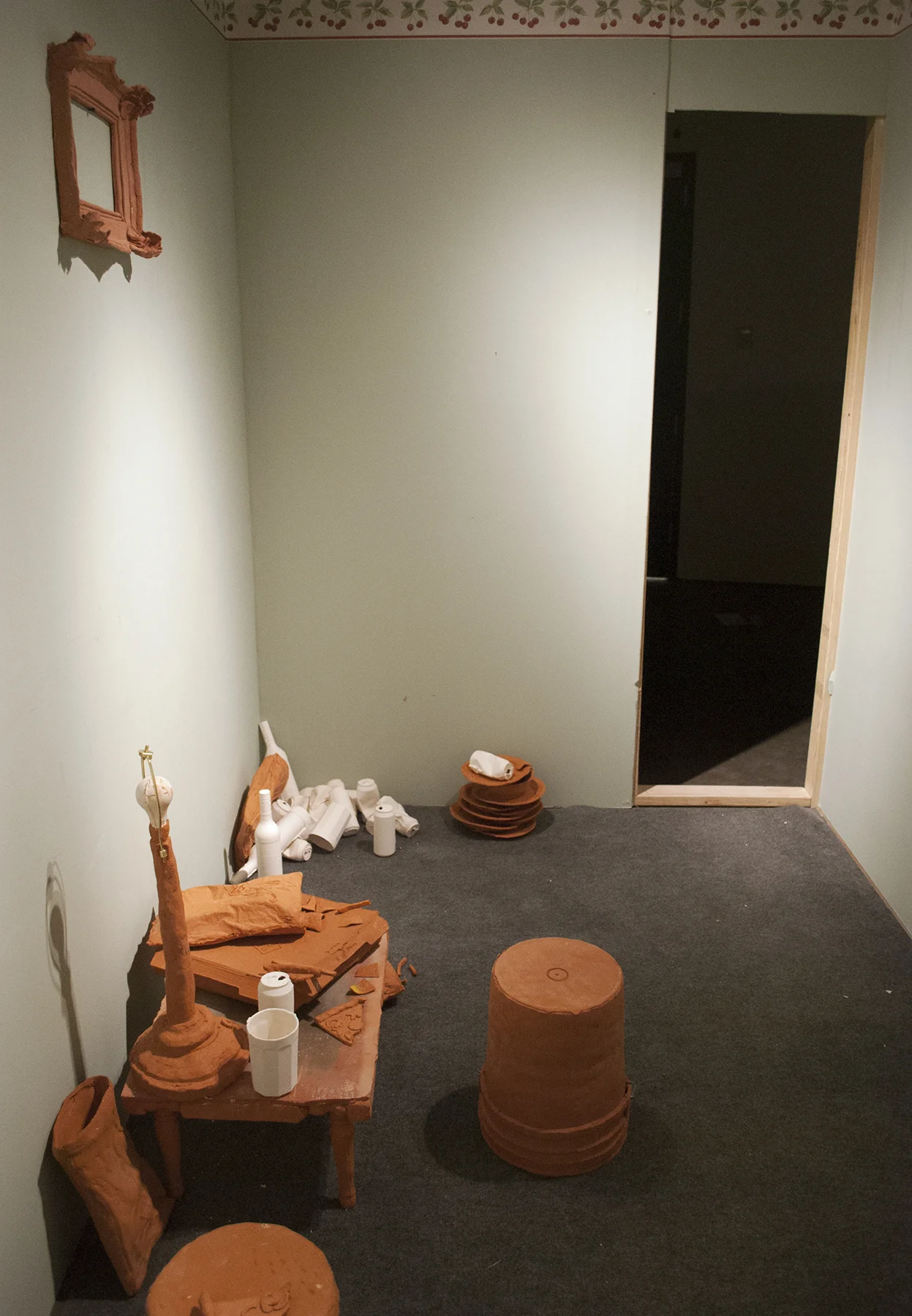 Terracotta, slip cast porcelain, found unfired cheese burger, carpet, metal, found cabinet, wallpaper, drywall, wood, latex Installation of life sized objects in 6’x12’x8’ room. 2018