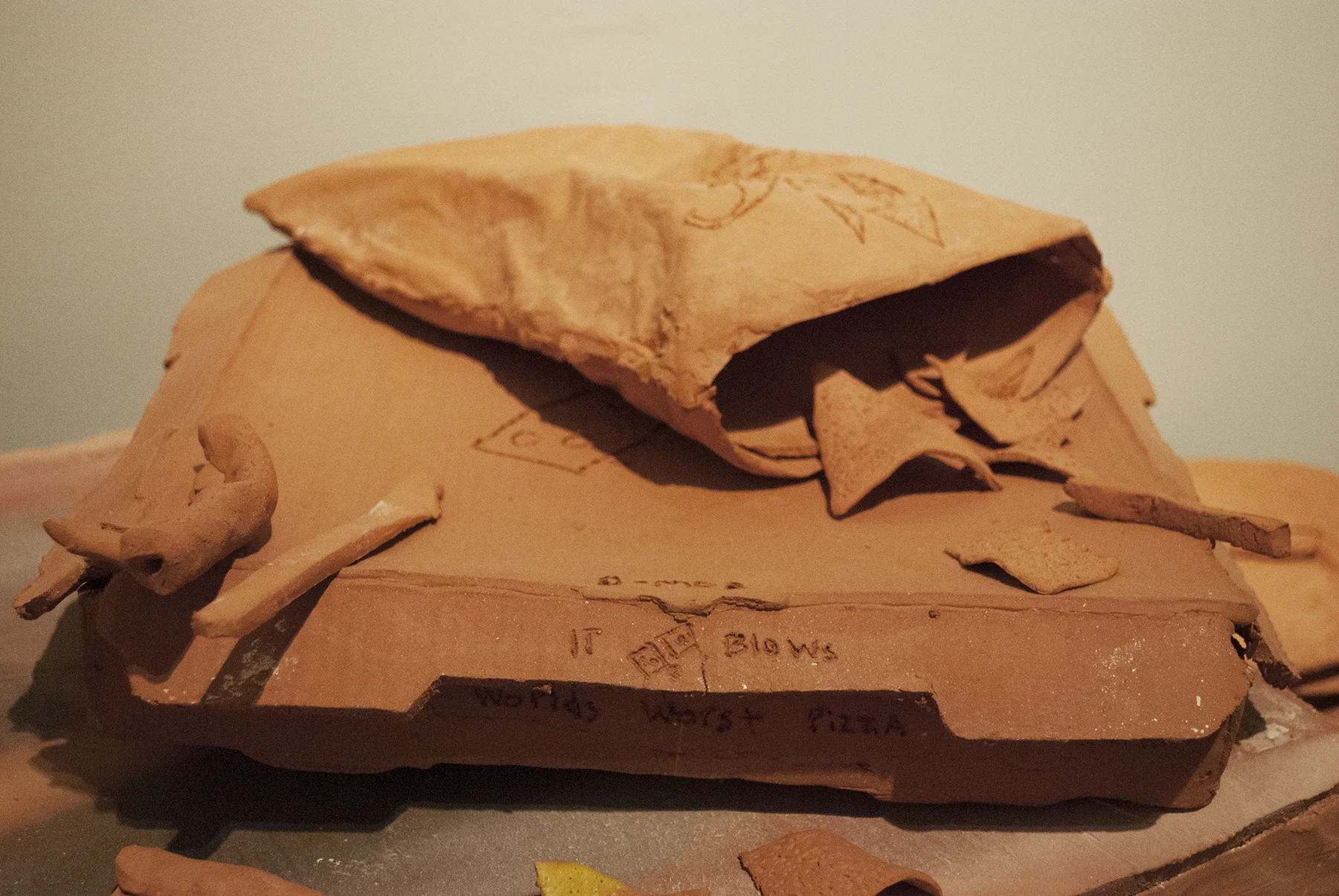 Terracotta, slip cast porcelain, found unfired cheese burger, carpet, metal, found cabinet, wallpaper, drywall, wood, latex Installation of life sized objects in 6’x12’x8’ room. 2018