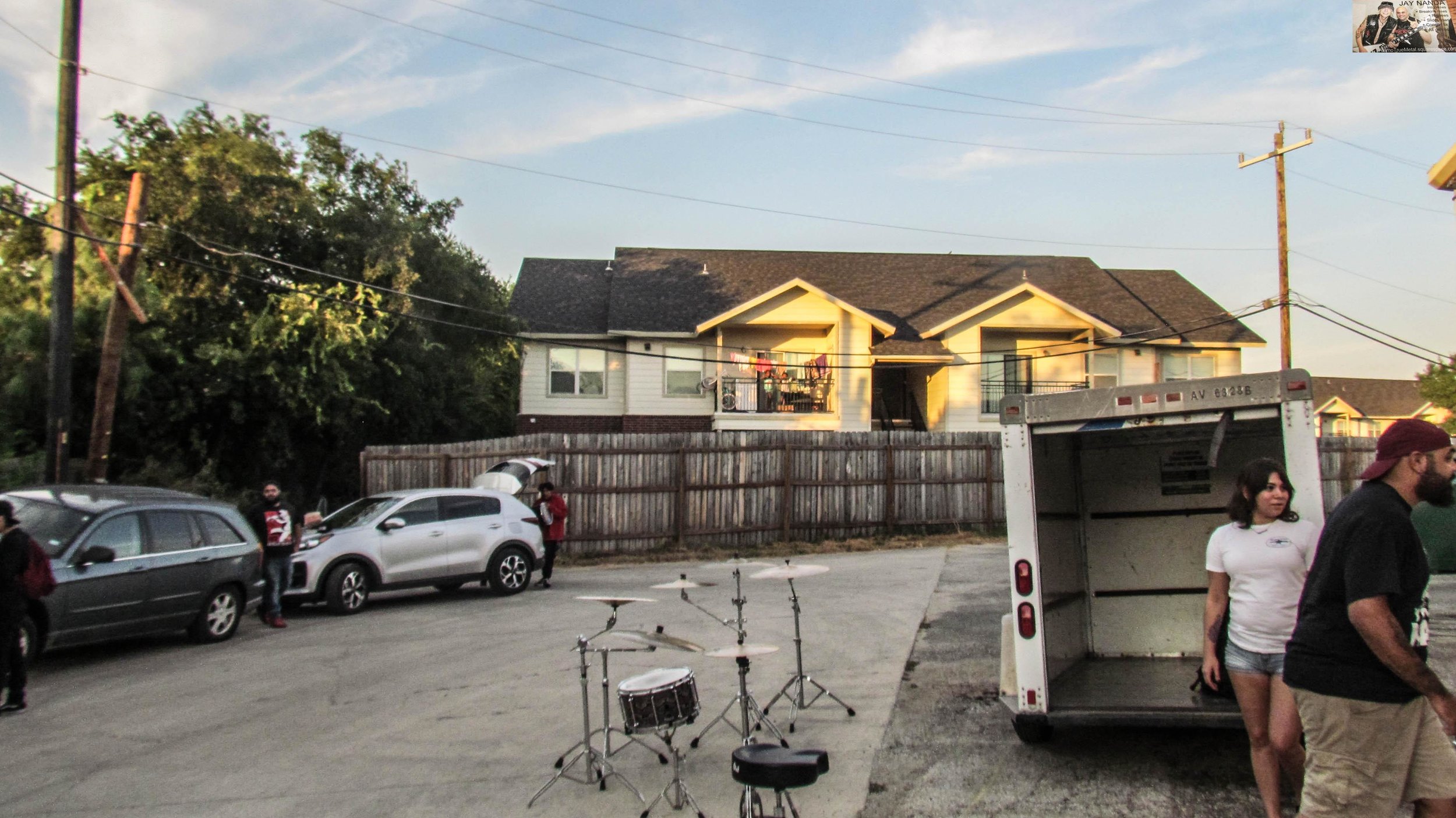 A pair of children watch the bands unload their equipment from their house.