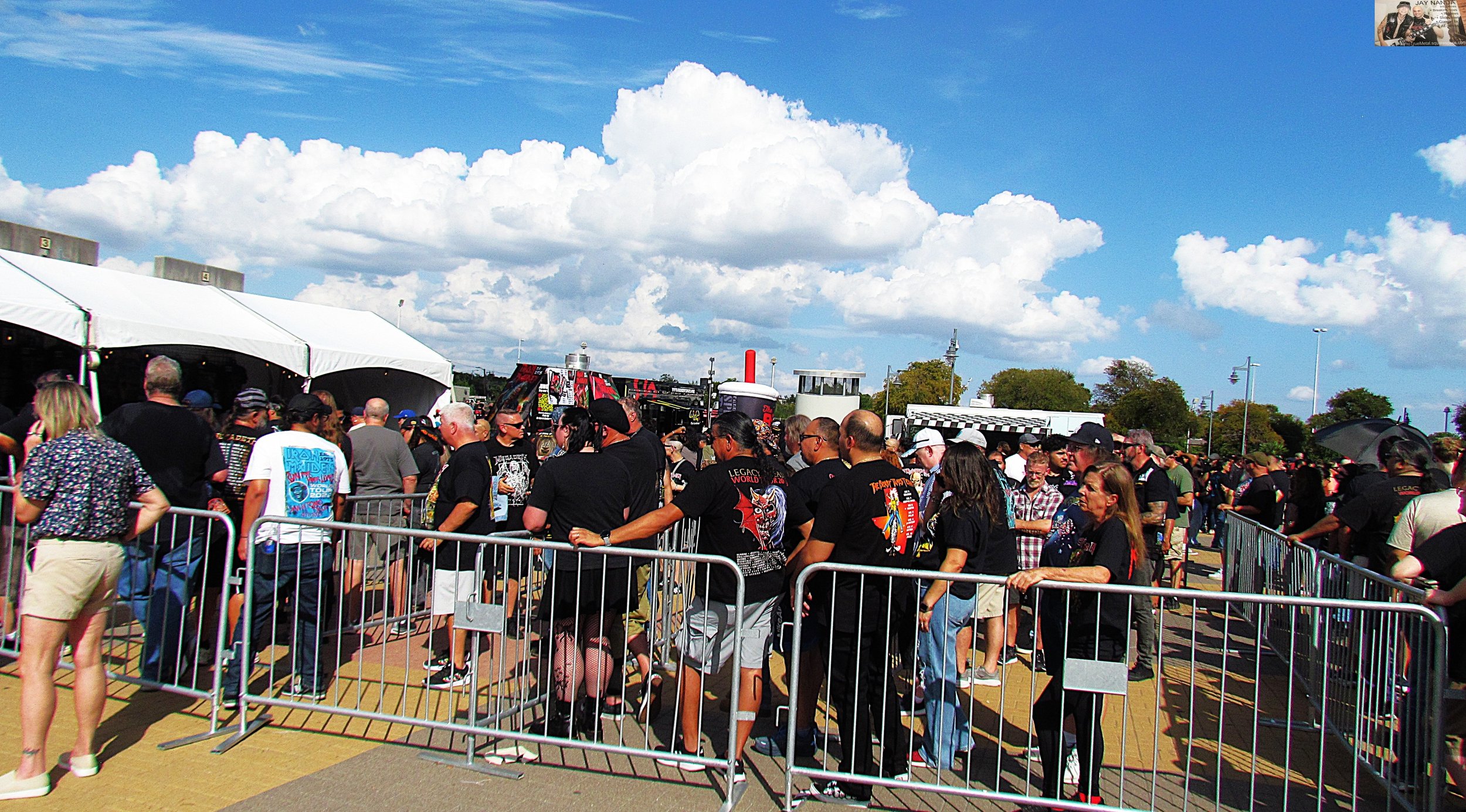  Fans wind their way up to one of the T-shirt and merch stands outside the dome on a muggy 95-degree day.  