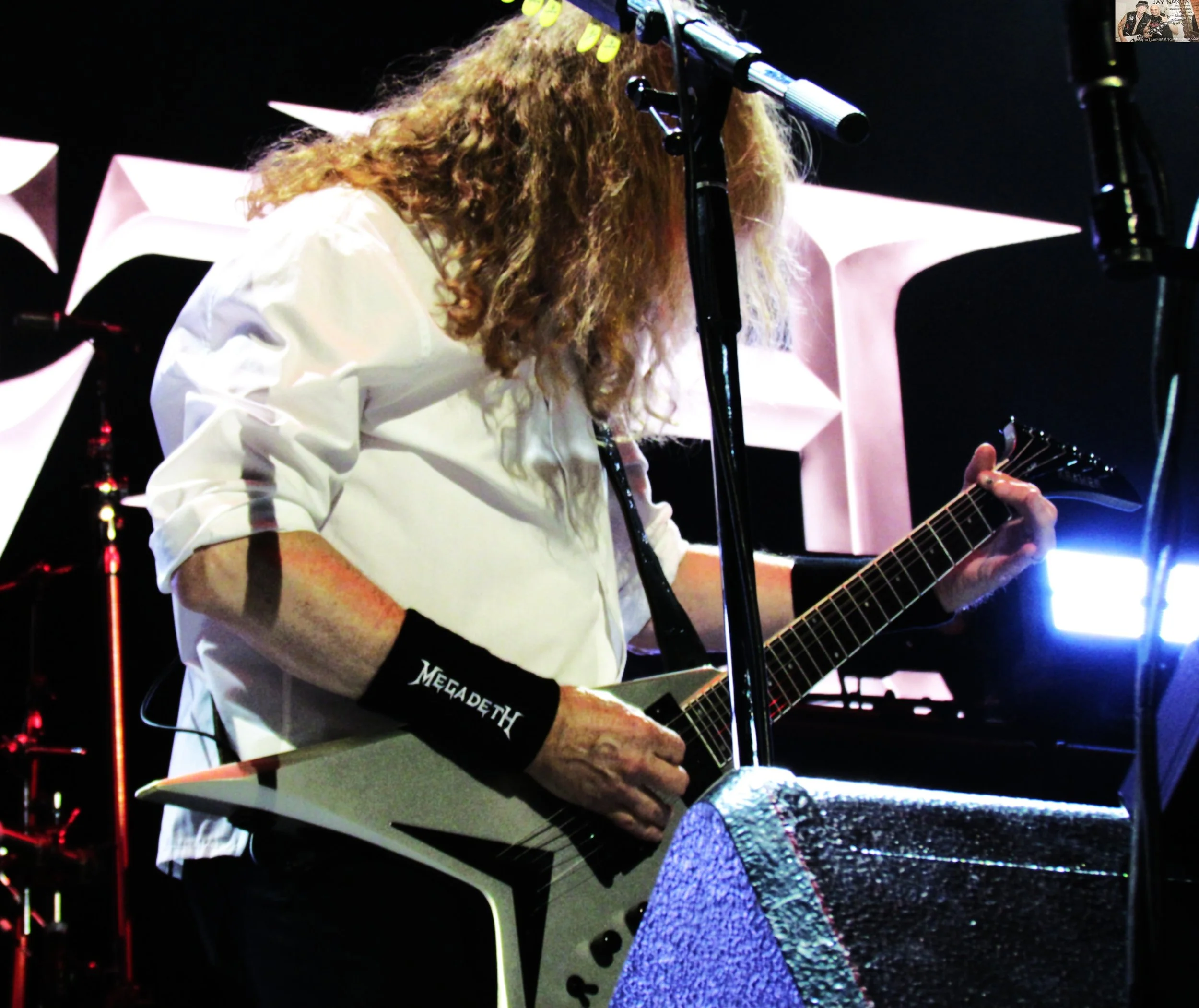  Mustaine’s white dress shirt and black branded wristbands are just as much staples as his Flying-V.  