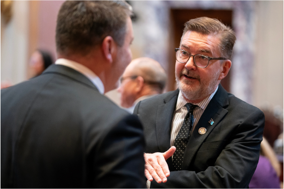 Senator Scott Dibble speaking on the senate floor with a colleague