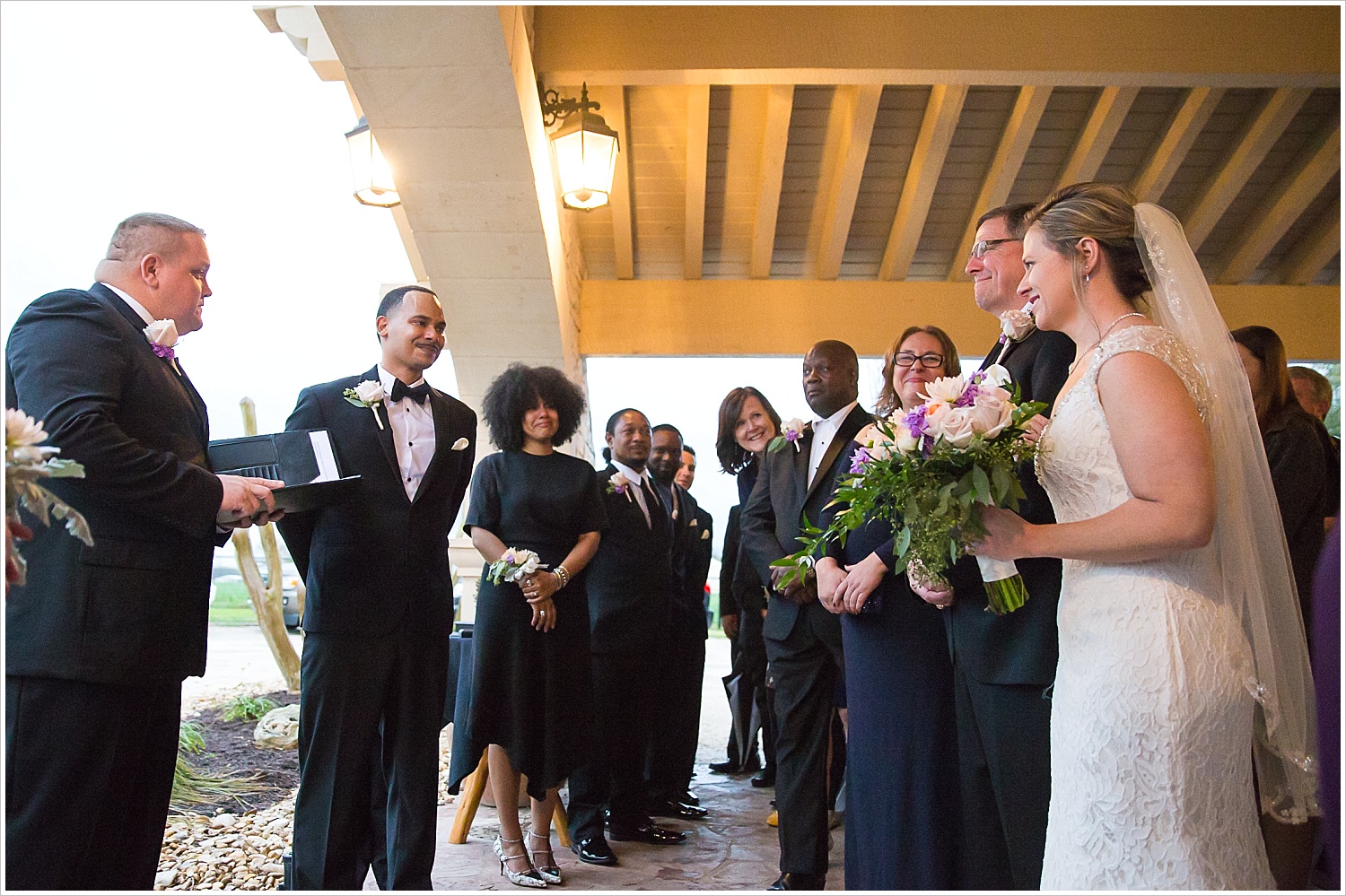 Groom's side smiles at bride coming down the aisle with her father