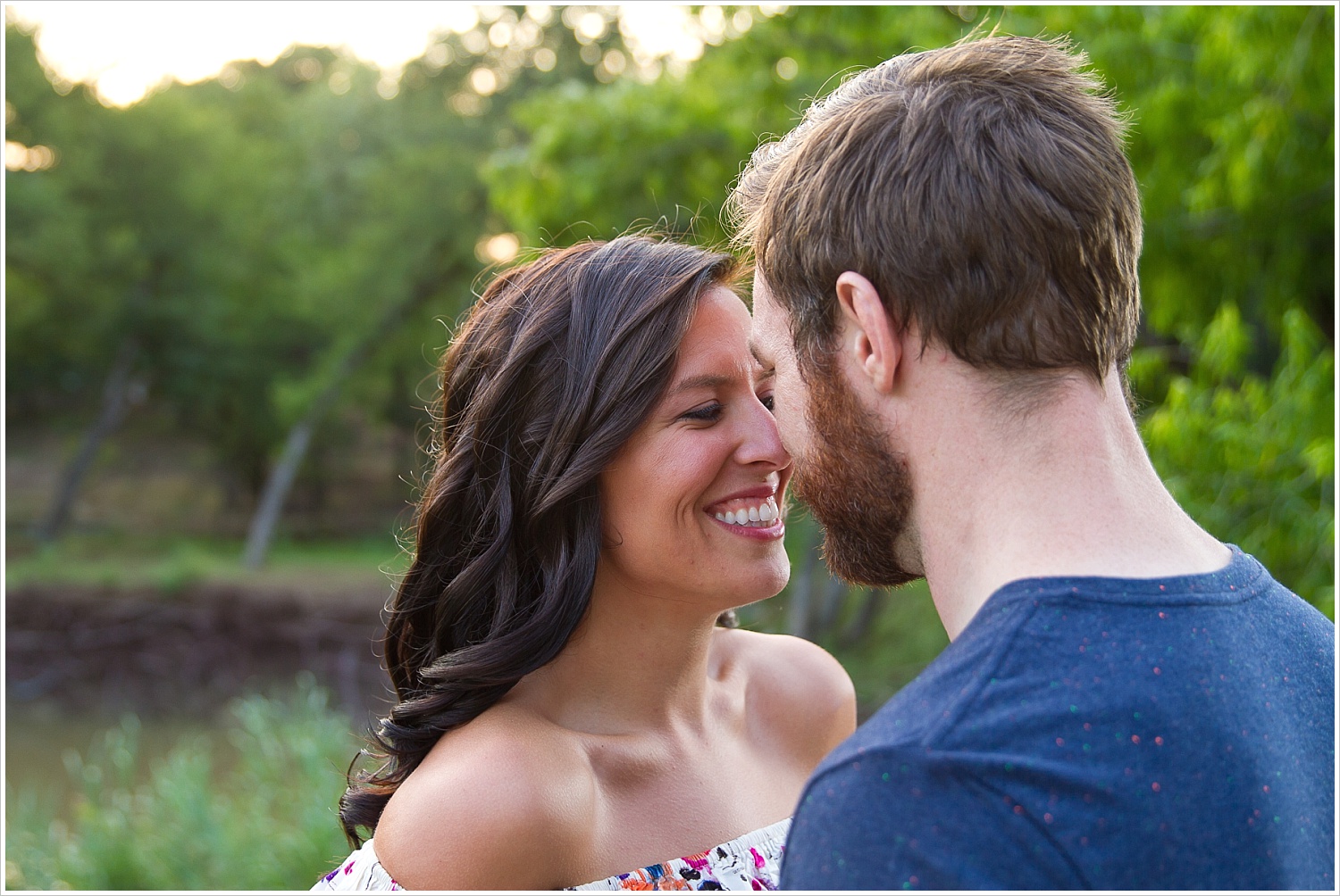 Randell & Fawn stand on a bridge in the park where Randell proposed at an engagement photography session in Frisco, Texas by Texas wedding photographers Jason & Melaina Photography, www.jasonandmelaina.com