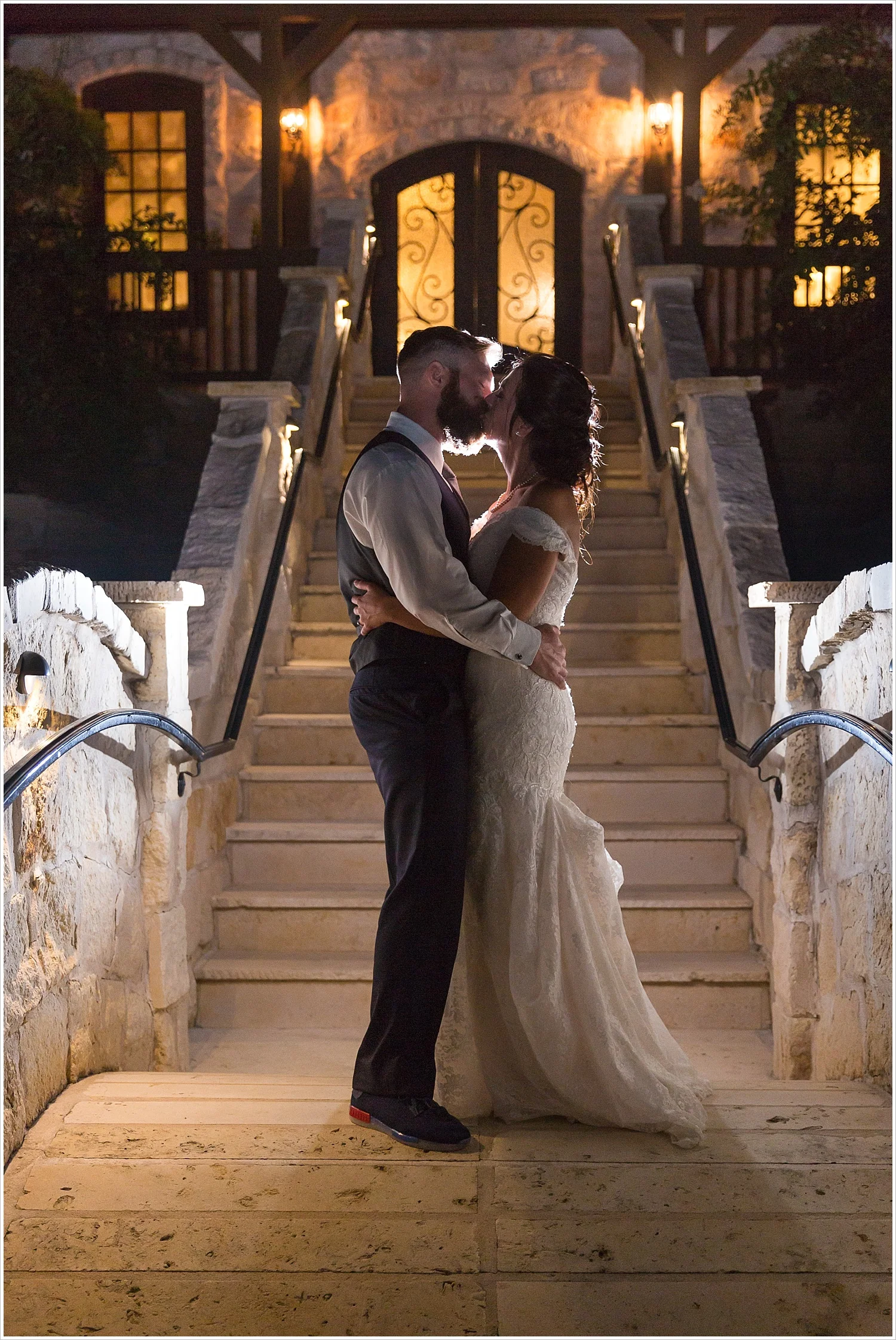 Bride and groom pose on stairs of Stone Hall, backlight with off-camera flash, summer blush and navy wedding at Stone Hall at The Springs in McKinney, Texas, Jason & Melaina Photography, www.jasonandmelaina.com