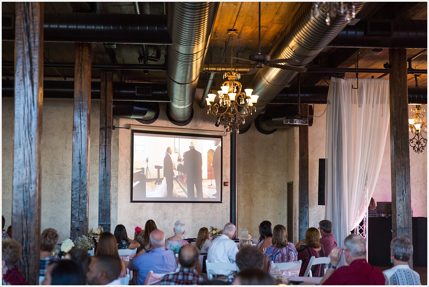 Guests watch video from wedding prior to reception, Navy and blush Texas Reception at The Phoenix Ballroom, Jason & Melaina Photography - www.jasonandmelaina.com