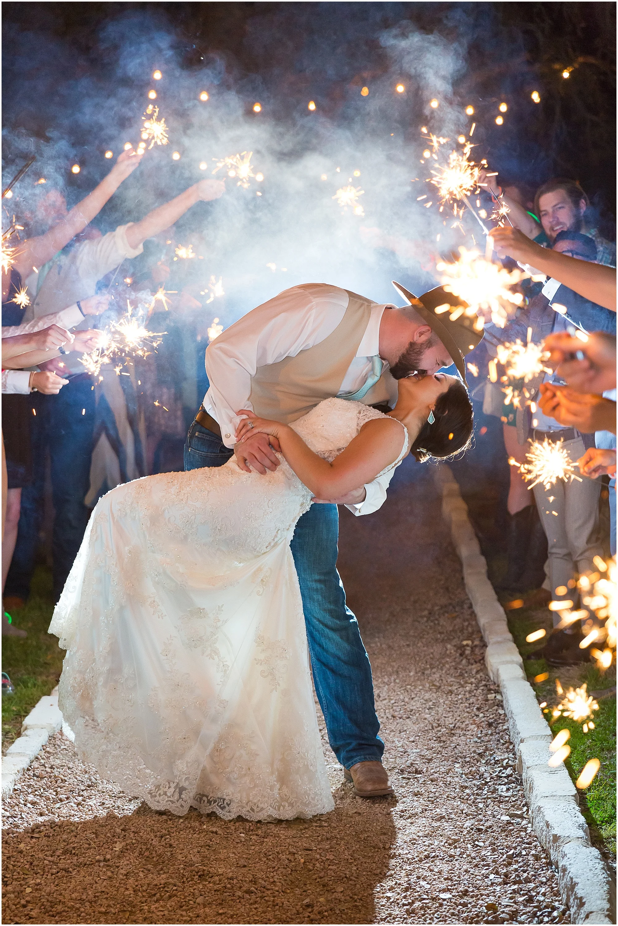Groom dips bride and kisses her during their sparkler exit - Peacock River Ranch - Jason & Melaina Photography