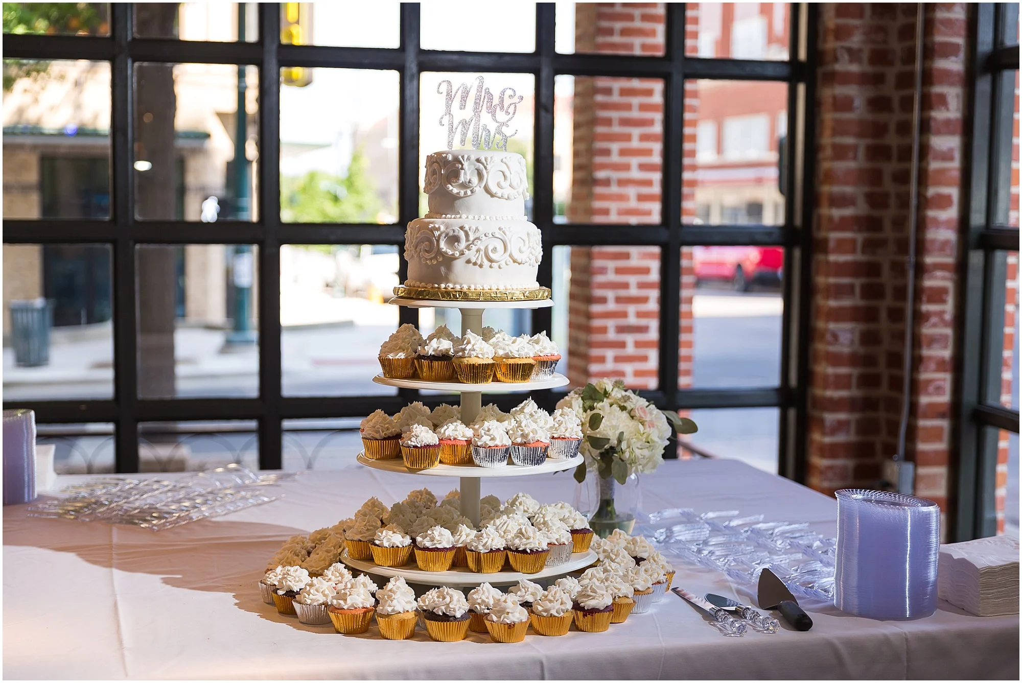 Cake and cupcake display at a warehouse wedding in Waco, Texas - www.jasonandmelaina.com