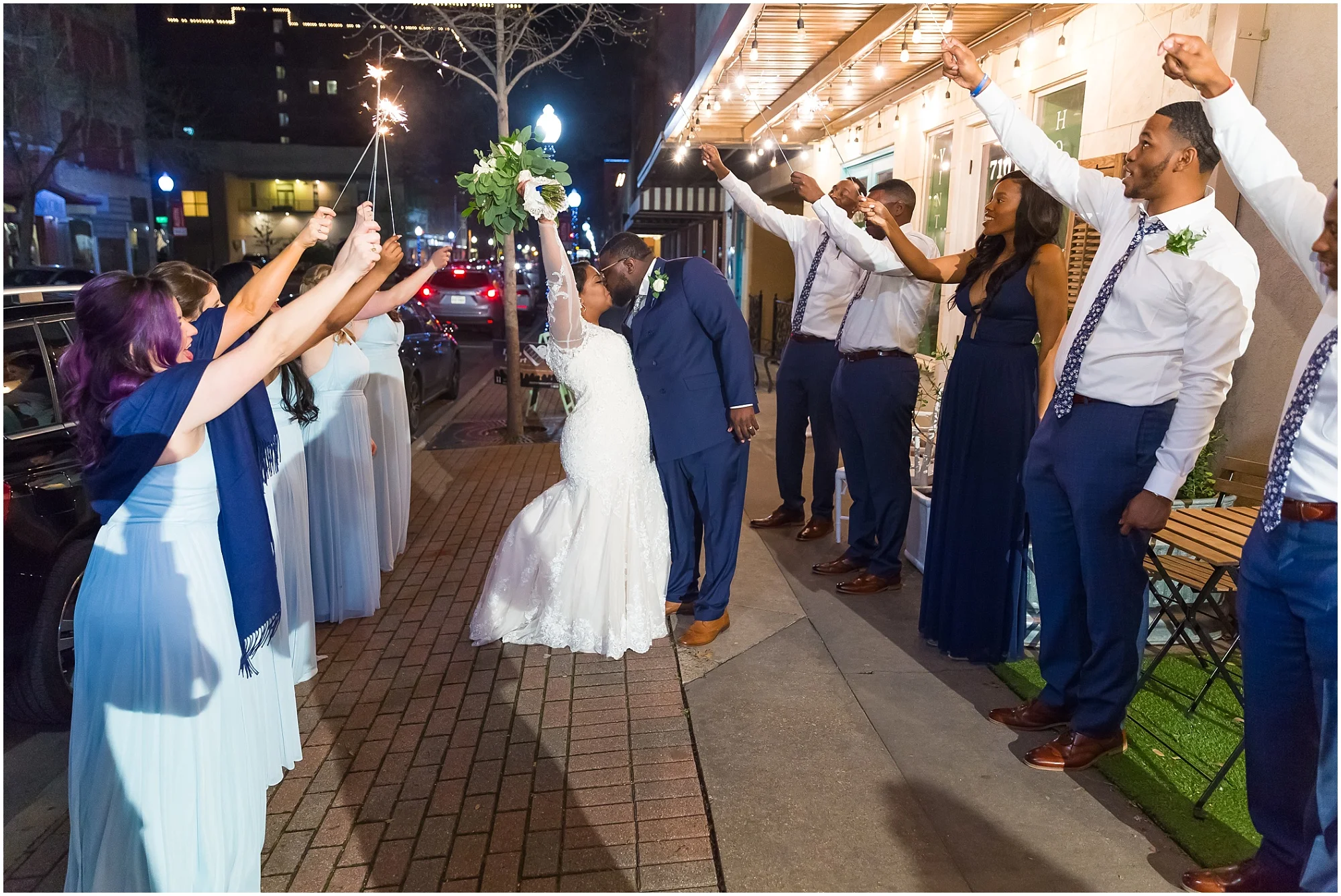 A bride and groom kiss under sparklers outside their reception at Cultivate 7Twelve in downtown Waco, Texas - Jason & Melaina Photography - www.jasonandmelaina.com