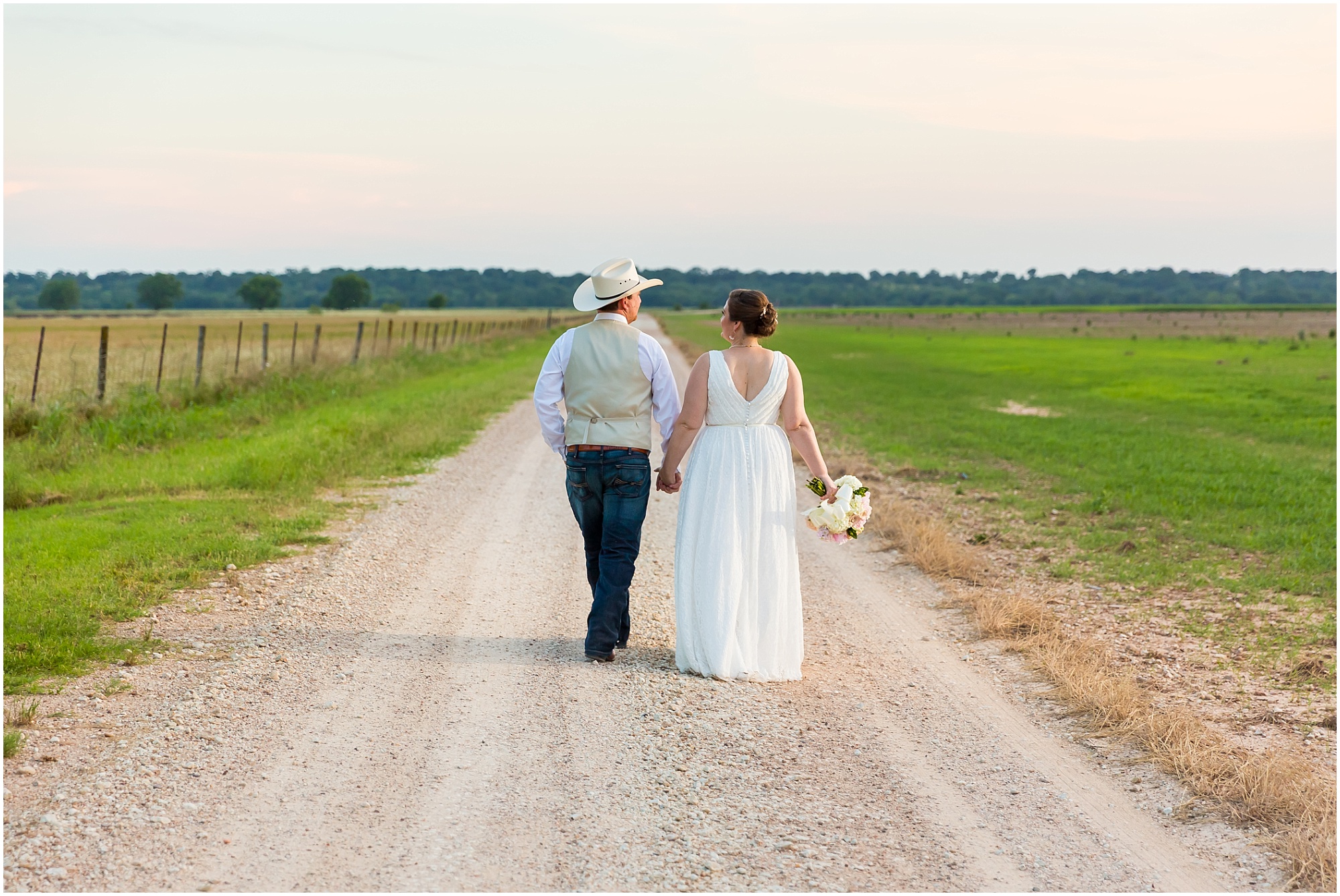 A just married couple walks hand-in-hand down a dirt road outside their wedding reception at Moon River Ranch | Jason & Melaina Photography | www.jasonandmelaina.com