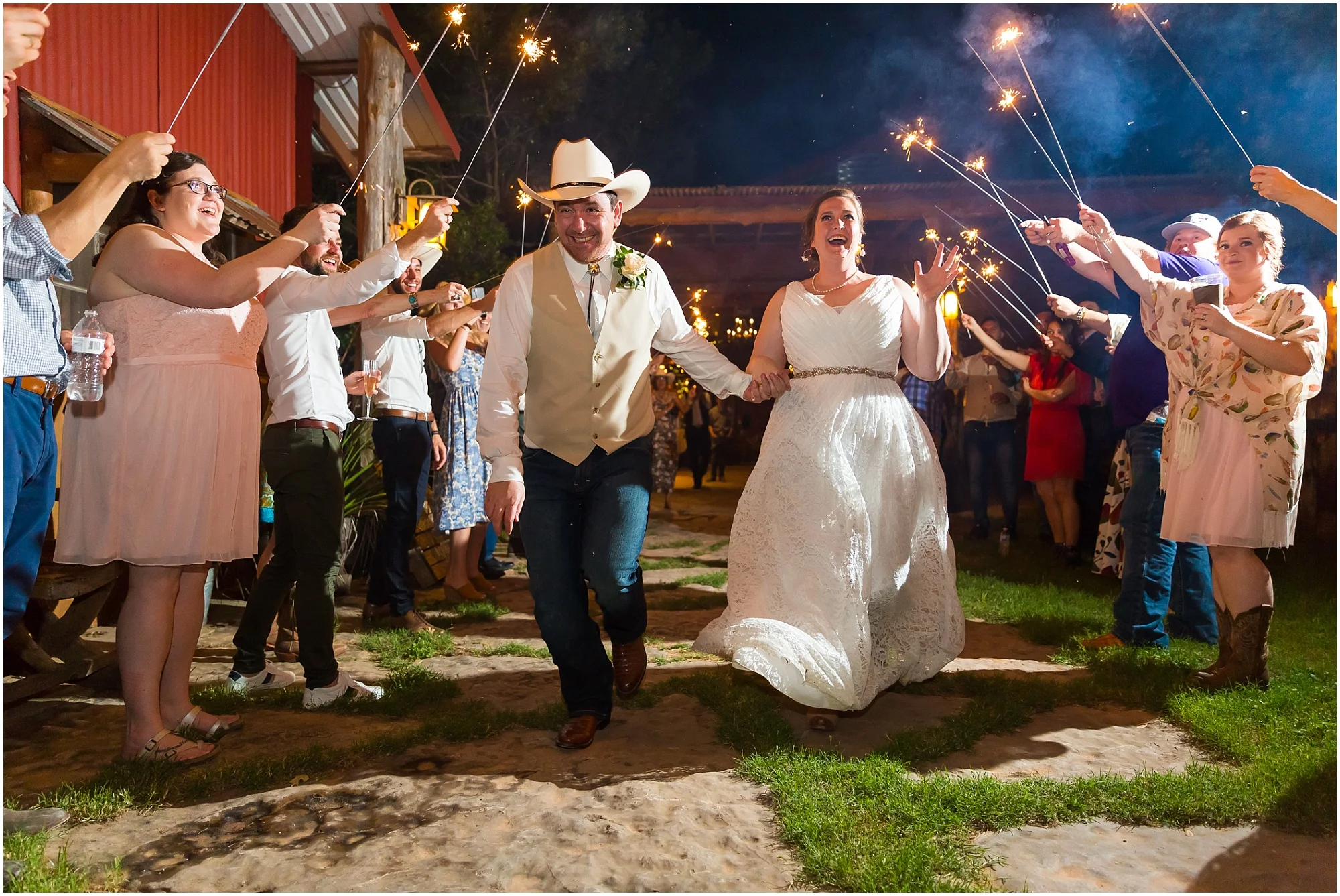 A groom and his bride run through a tunnel of their loved ones holding up sparklers as they leave their wedding reception at Moon River Ranch | Jason & Melaina Photography | www.jasonandmelaina.com