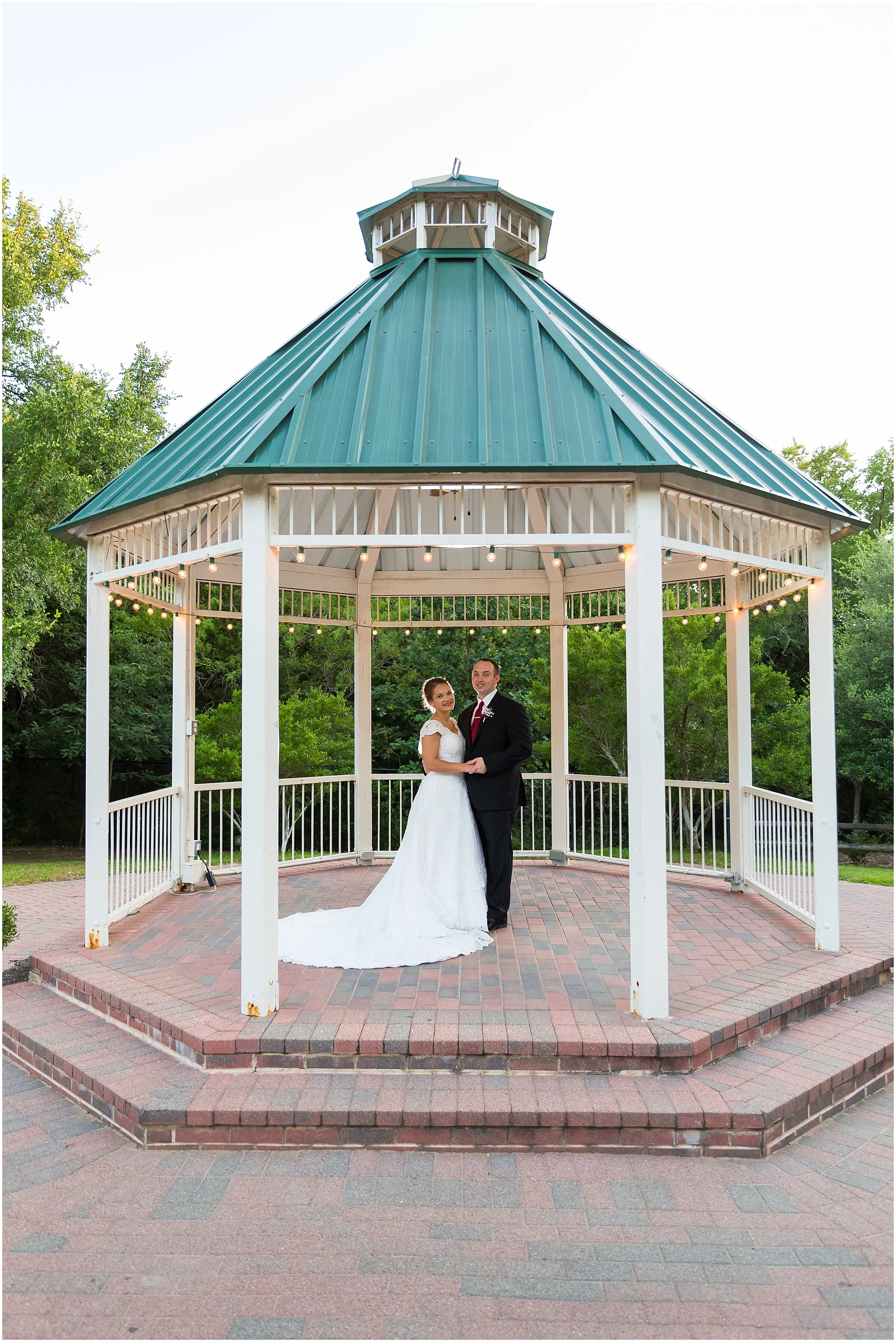 A groom and his bride pose together under the gazebo at Carleen Bright Arboretum in Woodway, Texas - Jason & Melaina Photography - www.jasonandmelaina.com