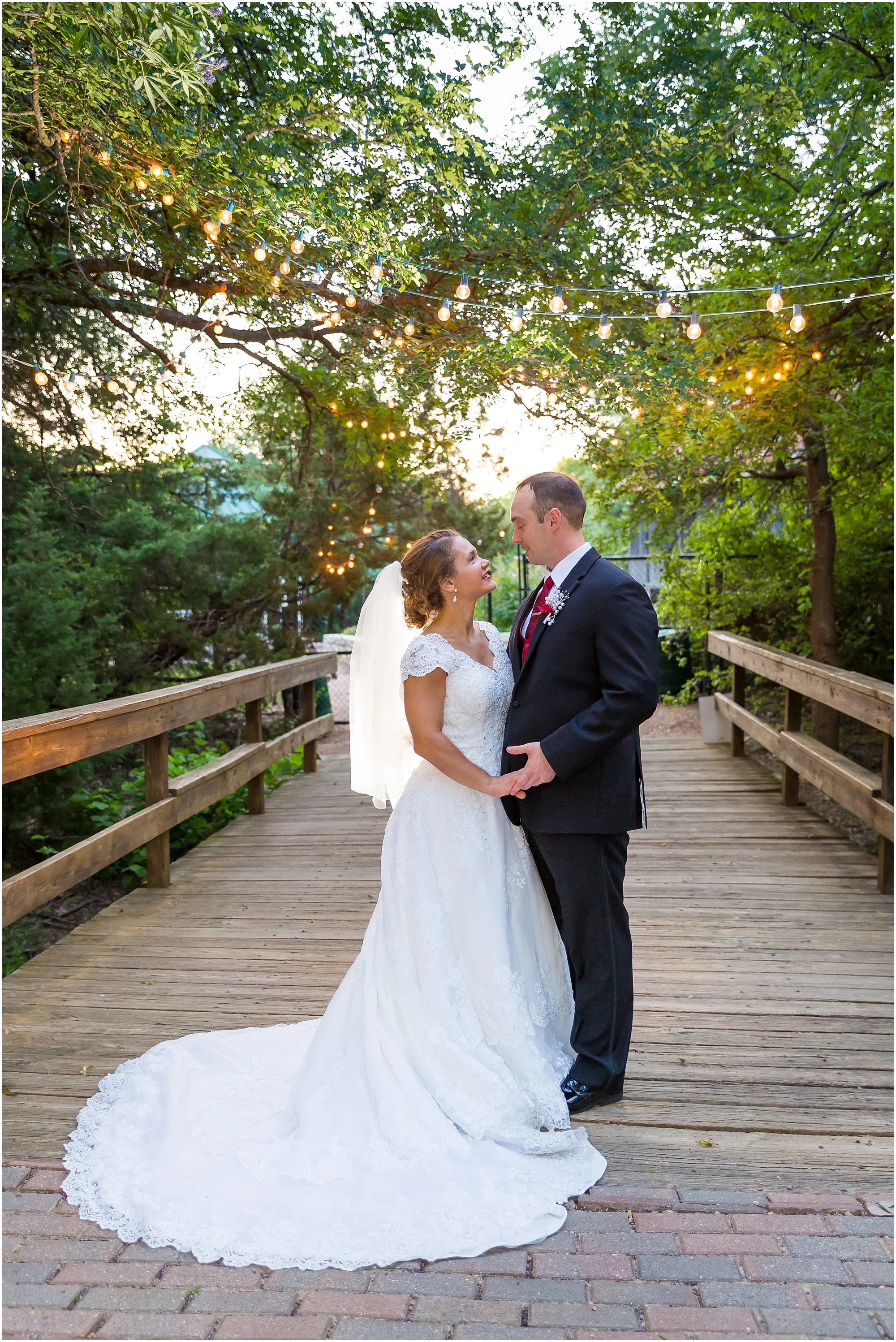 A just married couple holds one another on the bridge at Carleen Bright Arboretum in Woodway, Texas - Jason & Melaina Photography - www.jasonandmelaina.com