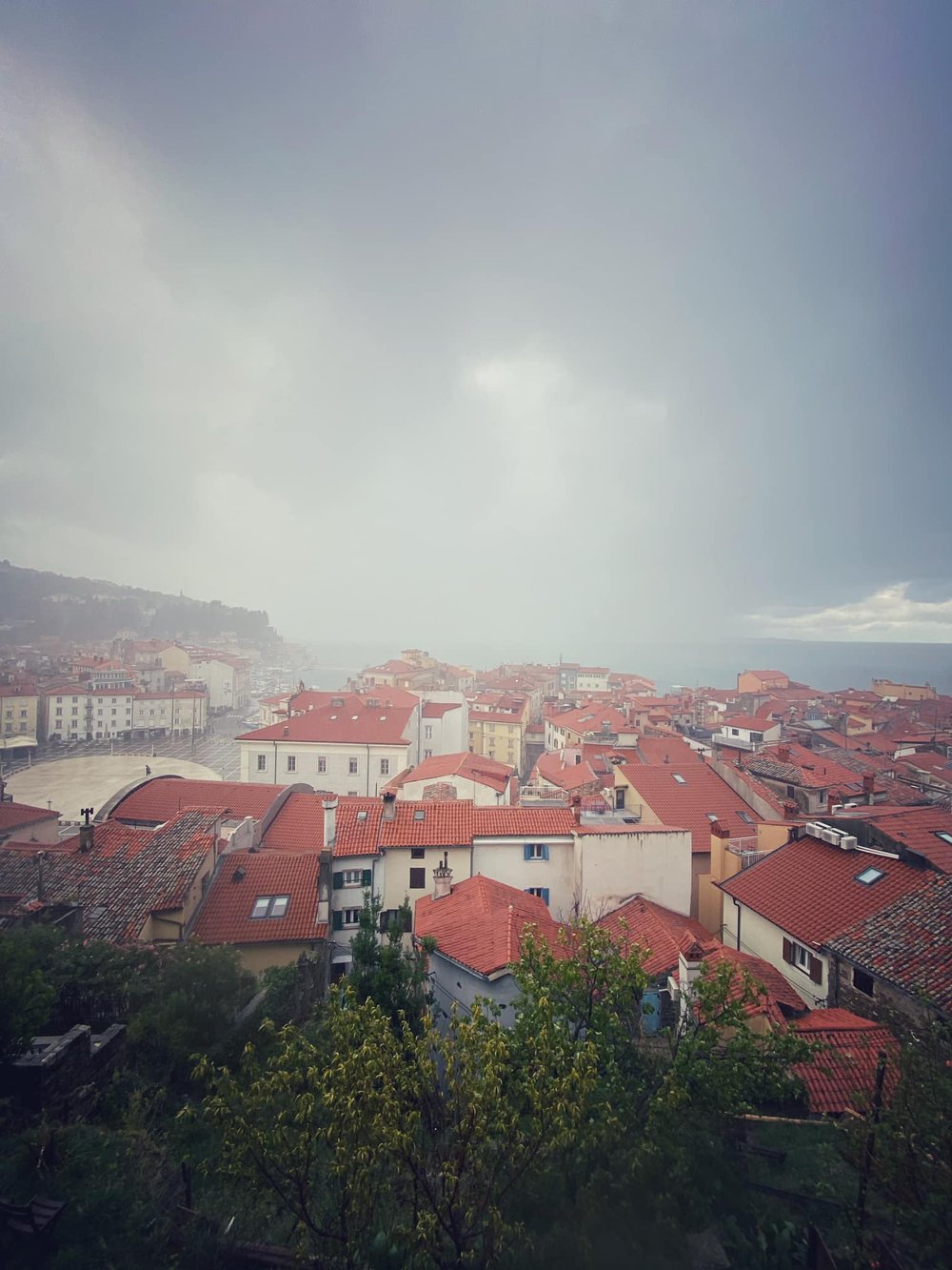  A stormy morning. As I picked my way down centuries-old, steep, suddenly slick cobblestones, I came across an elderly local woman struggling with a cane in one hand and an umbrella in the other. I offered an arm, took her things, and we navigated th