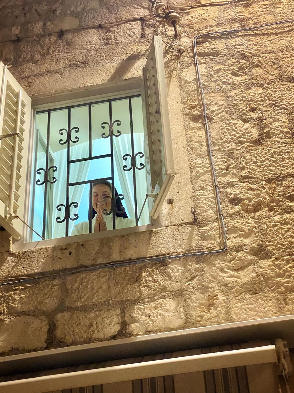  Behold, a smiling benediction from a second-floor window of a nunnery. 