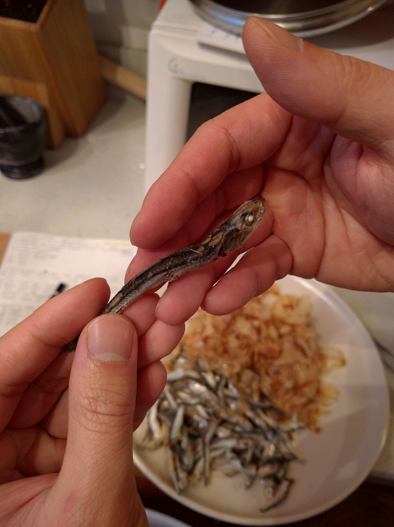 Purists remove the head and guts. Pull the head off and pinch the belly to remove its black entrails. 
