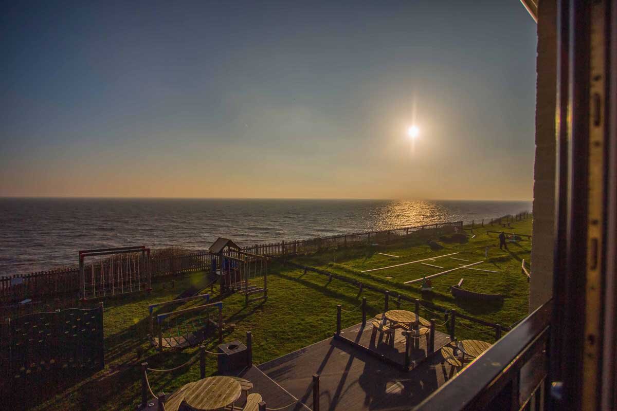 View of the sunset over the cliffs from a Waterside Park hotel room.jpg