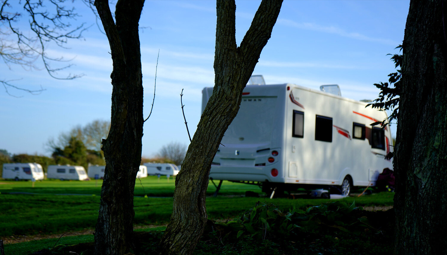 Touring caravan through trees at Brick Kiln.jpg