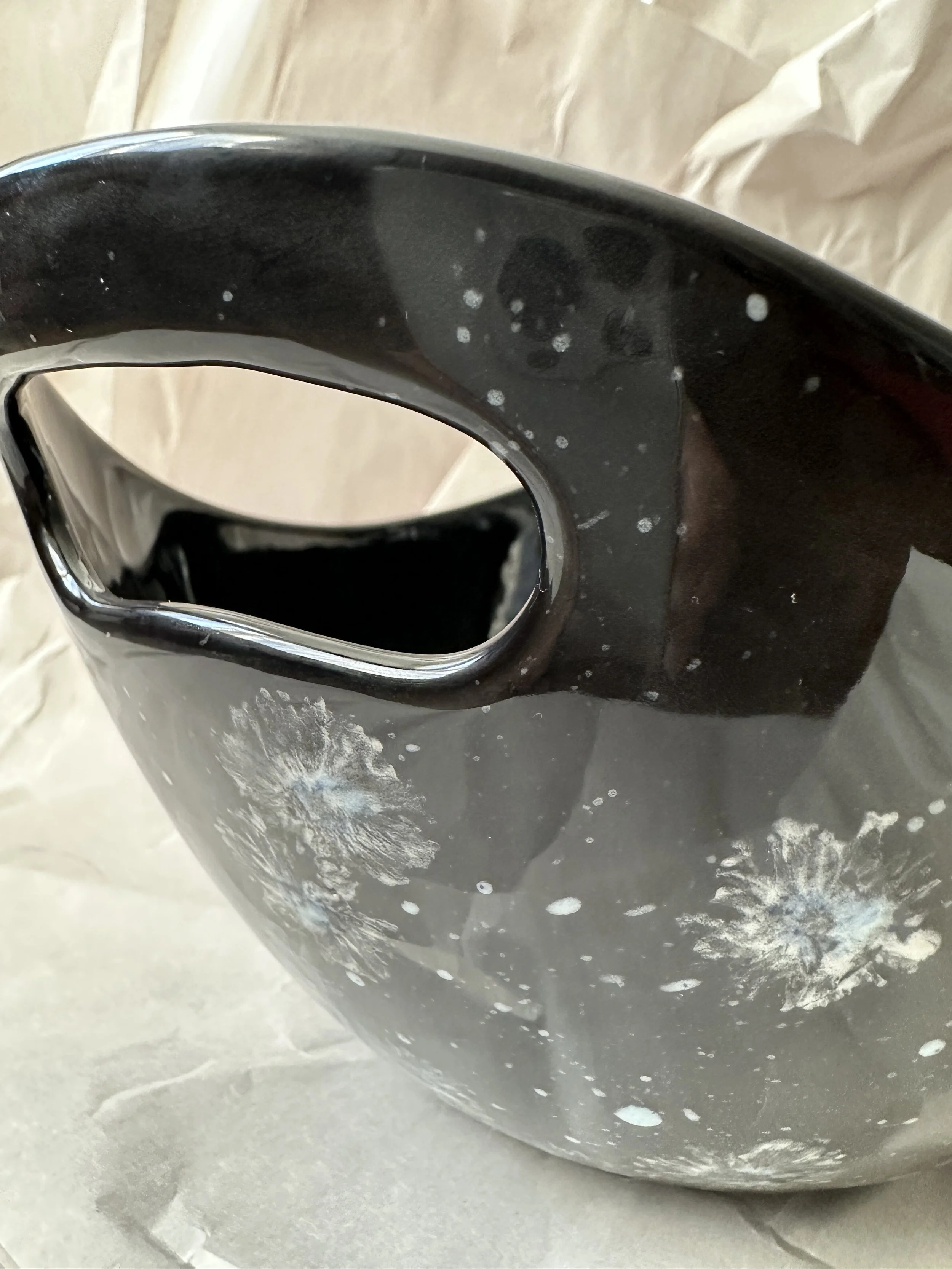  Boat shape bowl with handles 11” x 7.25” x 5.5” Daisy imprints in white, off white and a touch of blue on black ground. Food safe, dishwasher safe, but best to hand wash.  