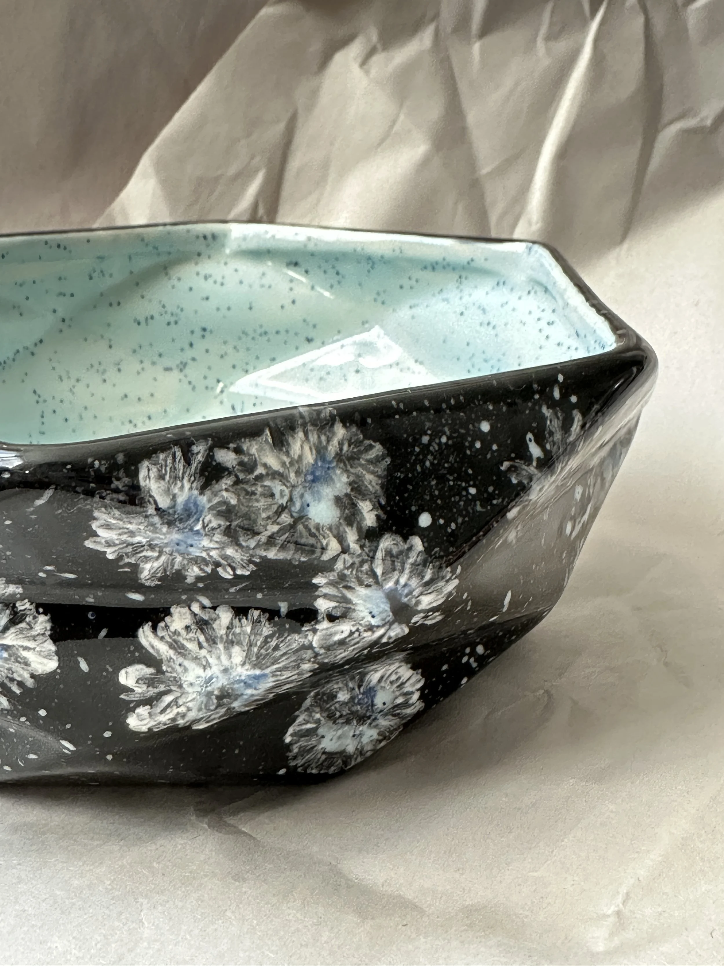  Faceted Serving Bowl 7.75” x 2.75” Daisy imprints in white, off white and a touch of blue on black ground. Food safe, dishwasher safe, but best to hand wash. 
