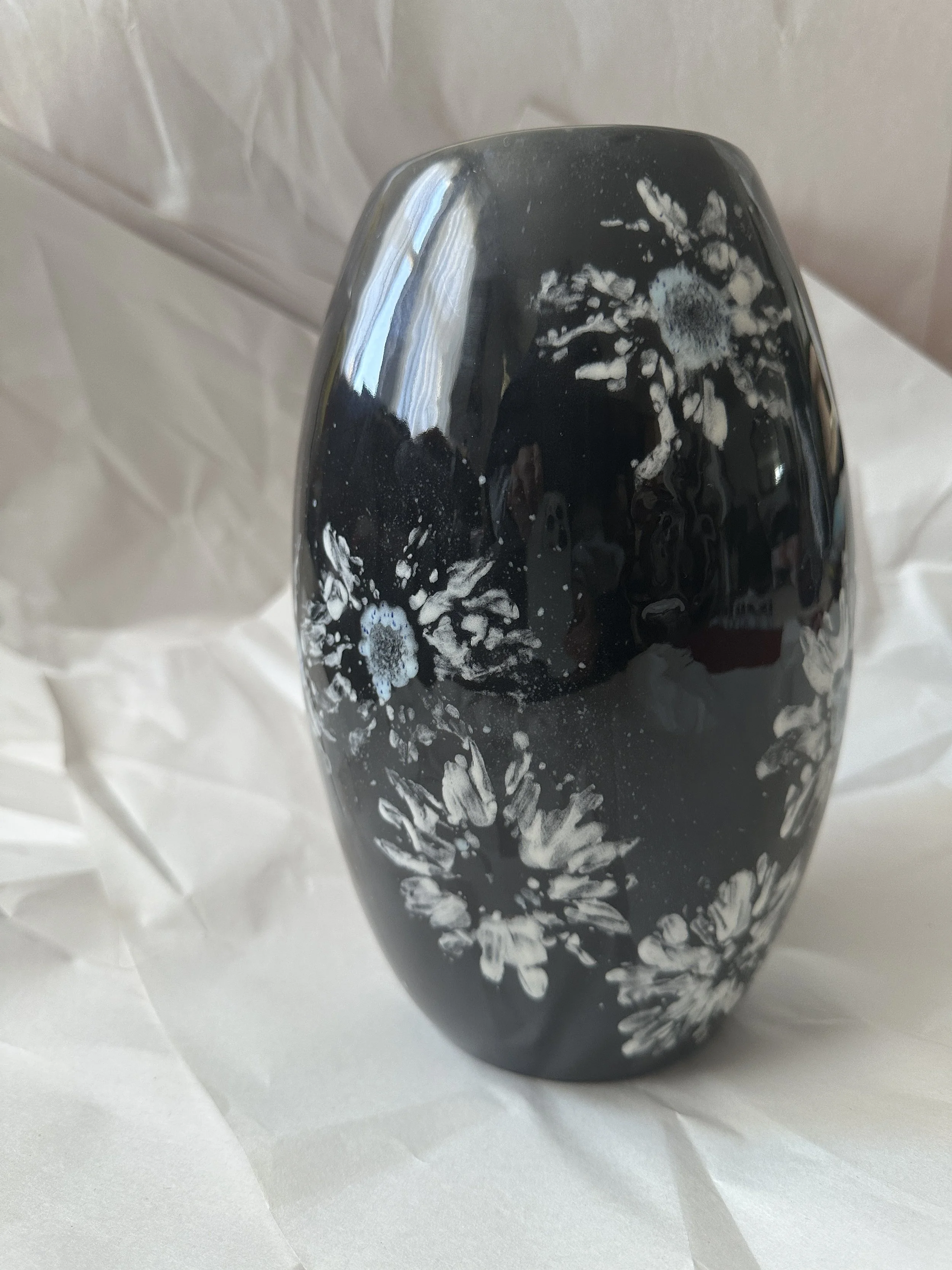  Tapered Vase 6.25” x 10” Daisy imprints in white, off white and a touch of blue on black ground. Blue inside.  Dishwasher safe, but best to hand wash. 