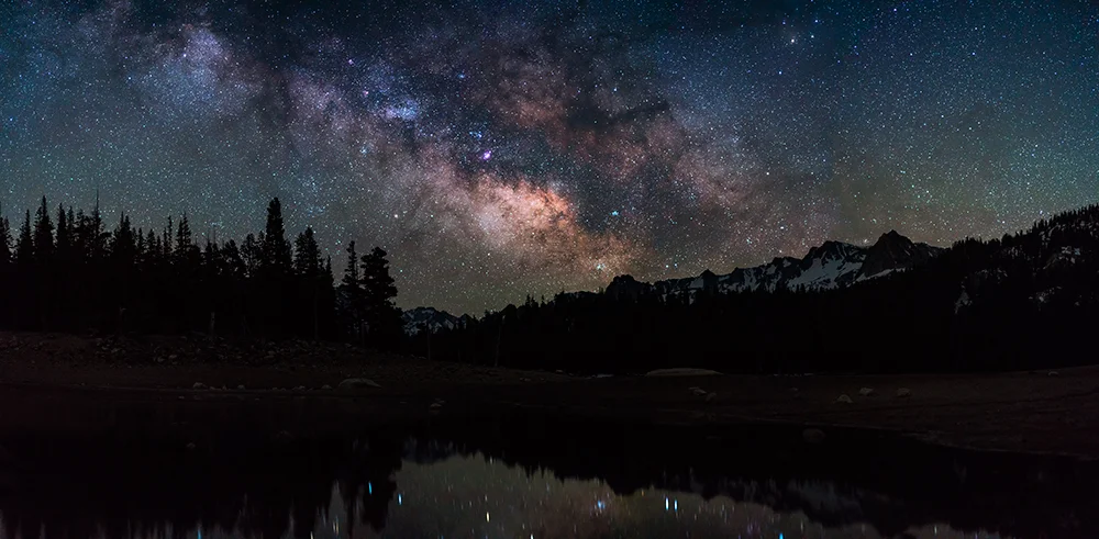 Shot with the Sony A7rII & Sony Zeiss 55mm f1.8 . Using the rule of 500 I divide 500 by 55 giving me 9.0909 seconds. I rounded up giving me 10 seconds. This allowed me to take 4 vertical separate images from left to right. Later stitching them as a panoramic in Adobe LightRoomCC resolving in a finished image with pinpoint stars.
