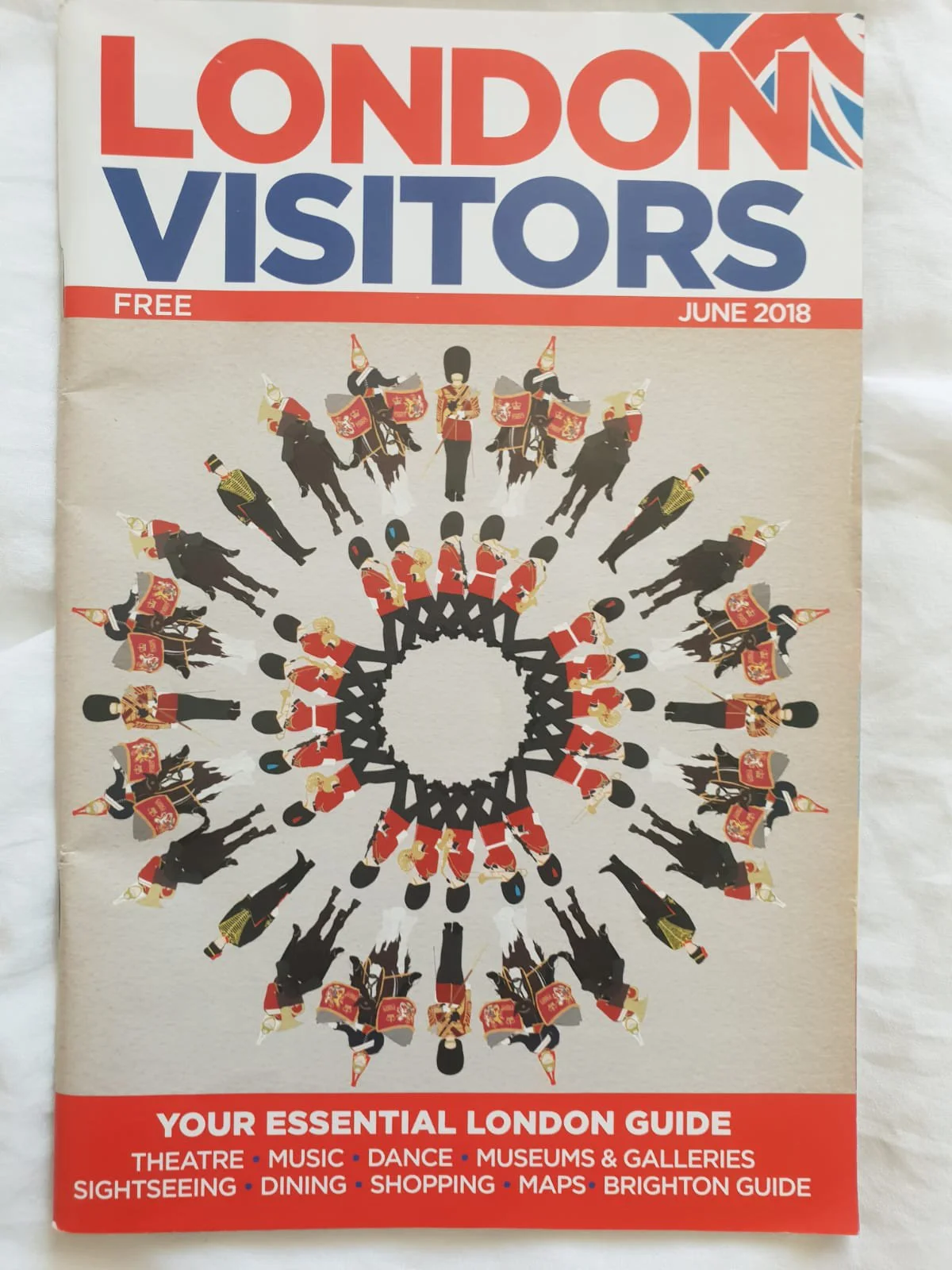 Cover of a travel guide titled 'London Visitors' from June 2018, featuring an illustration of guards in red uniforms with black hats and horses forming a circular pattern, with a list of activities and attractions in London.