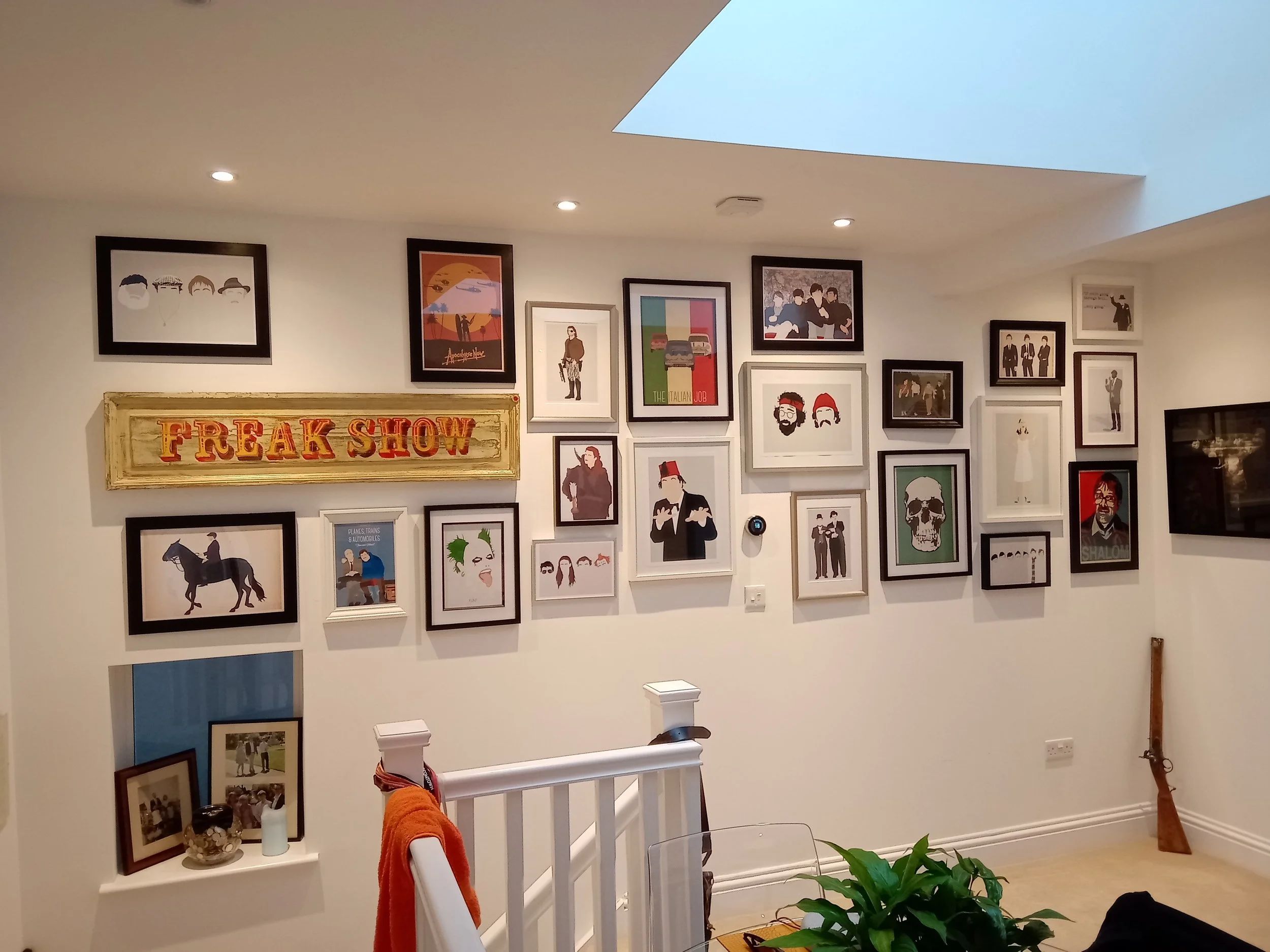 Living room wall decorated with framed arts and posters, including a 