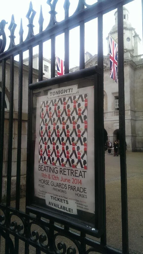 Poster announcing a beating retreat event featuring a parade of horses and horse guards on June 11th and 12th, 2014, with music and fireworks, located near a historic building with Union Jack flags.
