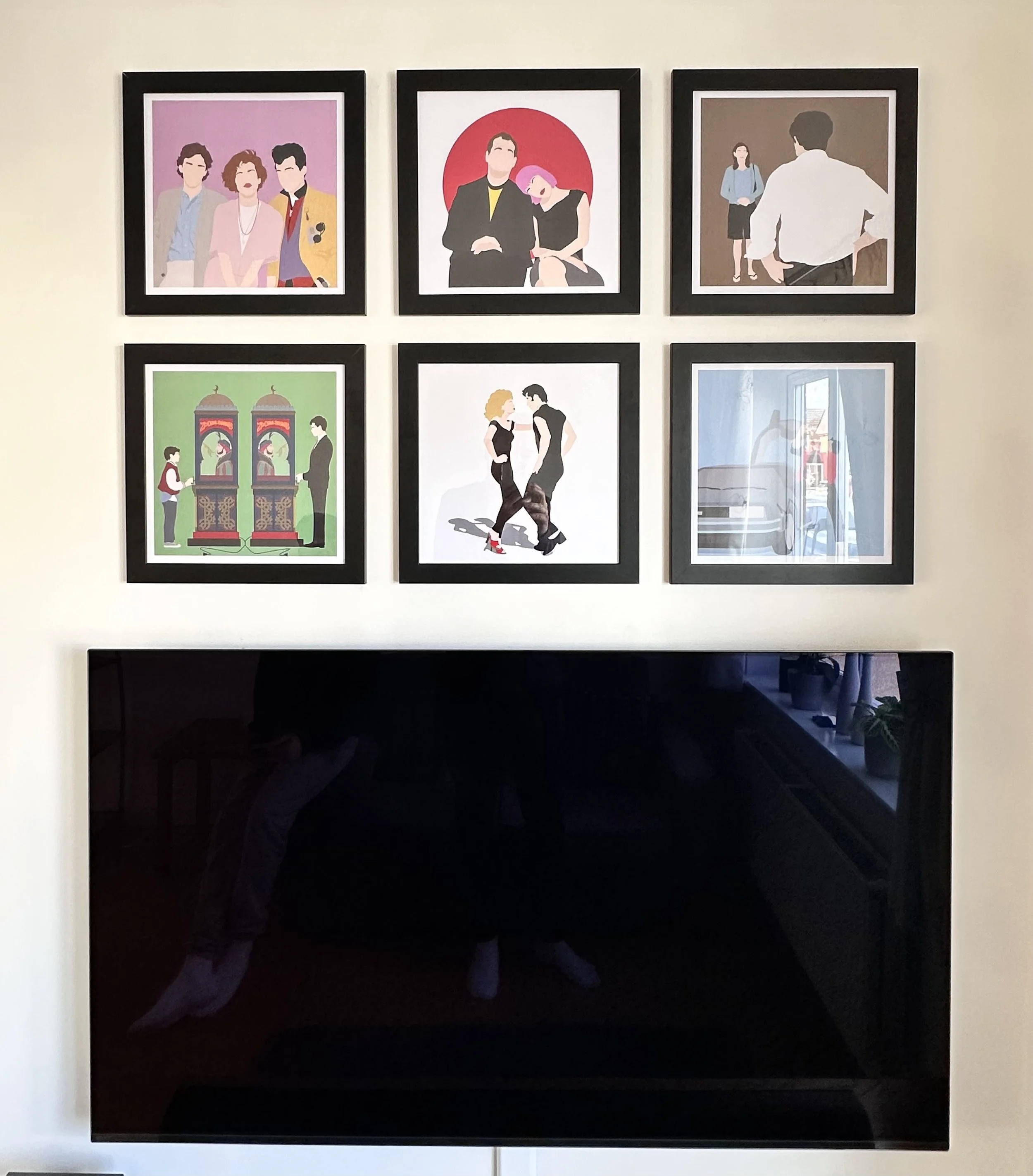 Six framed digital illustrations of people in various interactions hang on a white wall above a black fireplace. The top row features three portraits: the first shows three people, the second a man and woman sitting together against a red background,