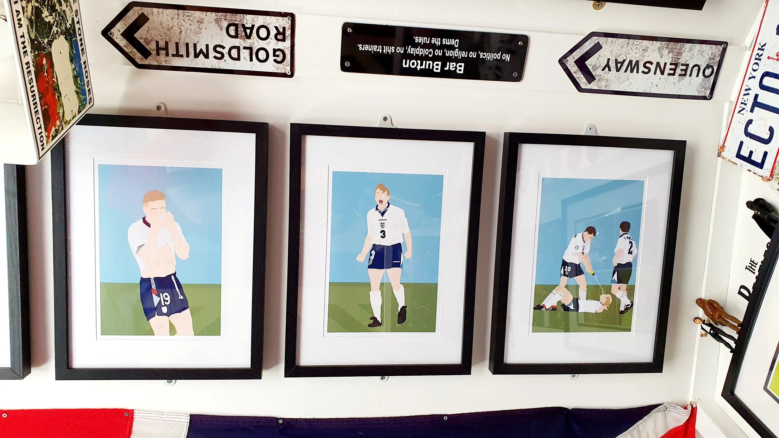 Three framed illustrations of athletes celebrating or interacting on a field, with vintage road signs above them.