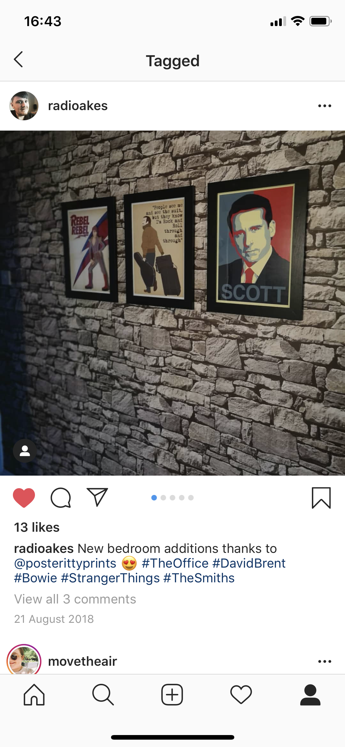 Three framed posters hanging on a stone wall. The first features a stylized woman with a lightning bolt, the second has a man with a suitcase and quote about Rolling through and through, and the third is a portrait of David Brent from The Office with