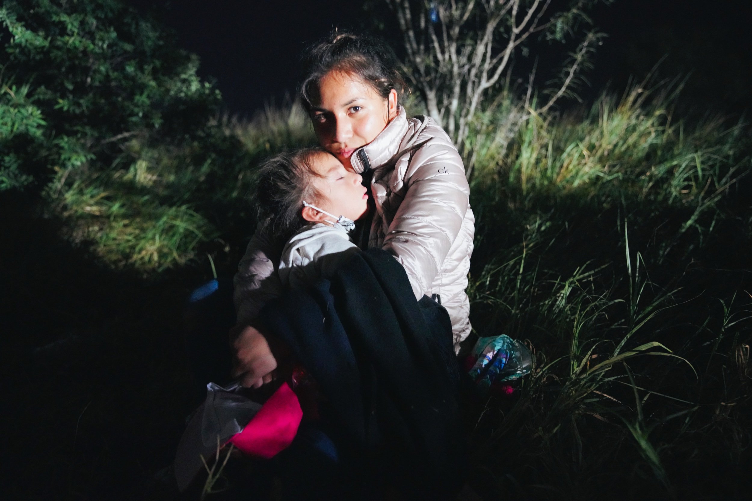  A migrant woman and her daughter wait in the long USA Border Patrol line, to be processed. This night more than 400 people crossed the Rio Grande, looking for asylum in the USA. July 2021. Roma, TX.  