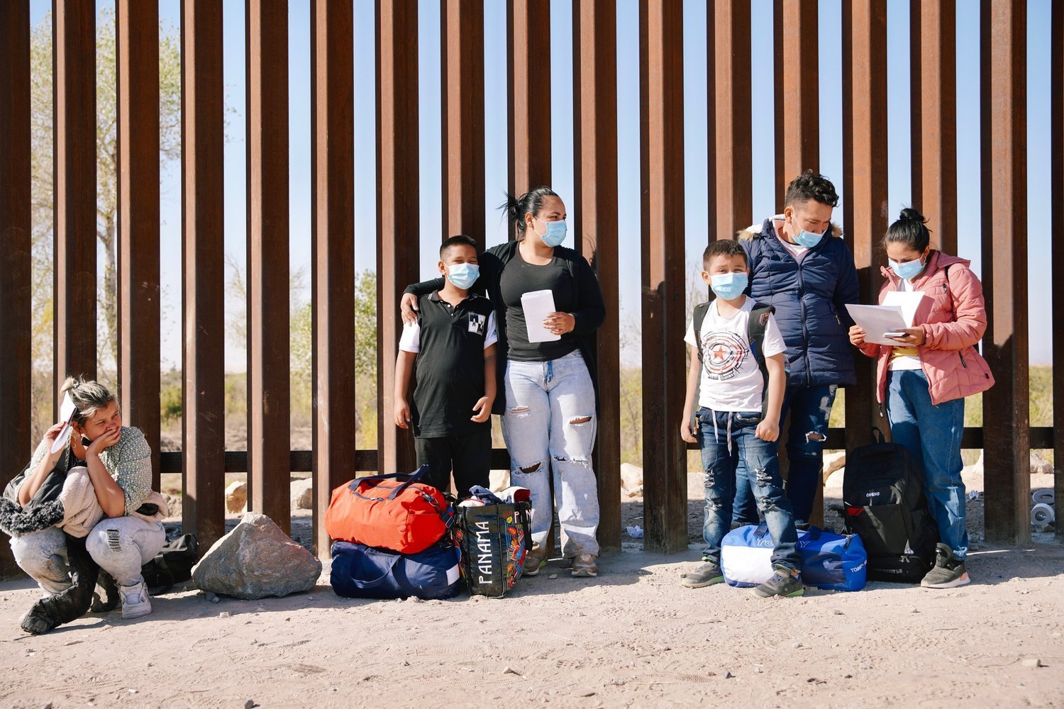  A group of migrants from Cuba, Venezuela, and Colombia wait at the USA border wall in Yuma, Arizona, to turn themselves into US Border Patrol and ask for Asylum. 