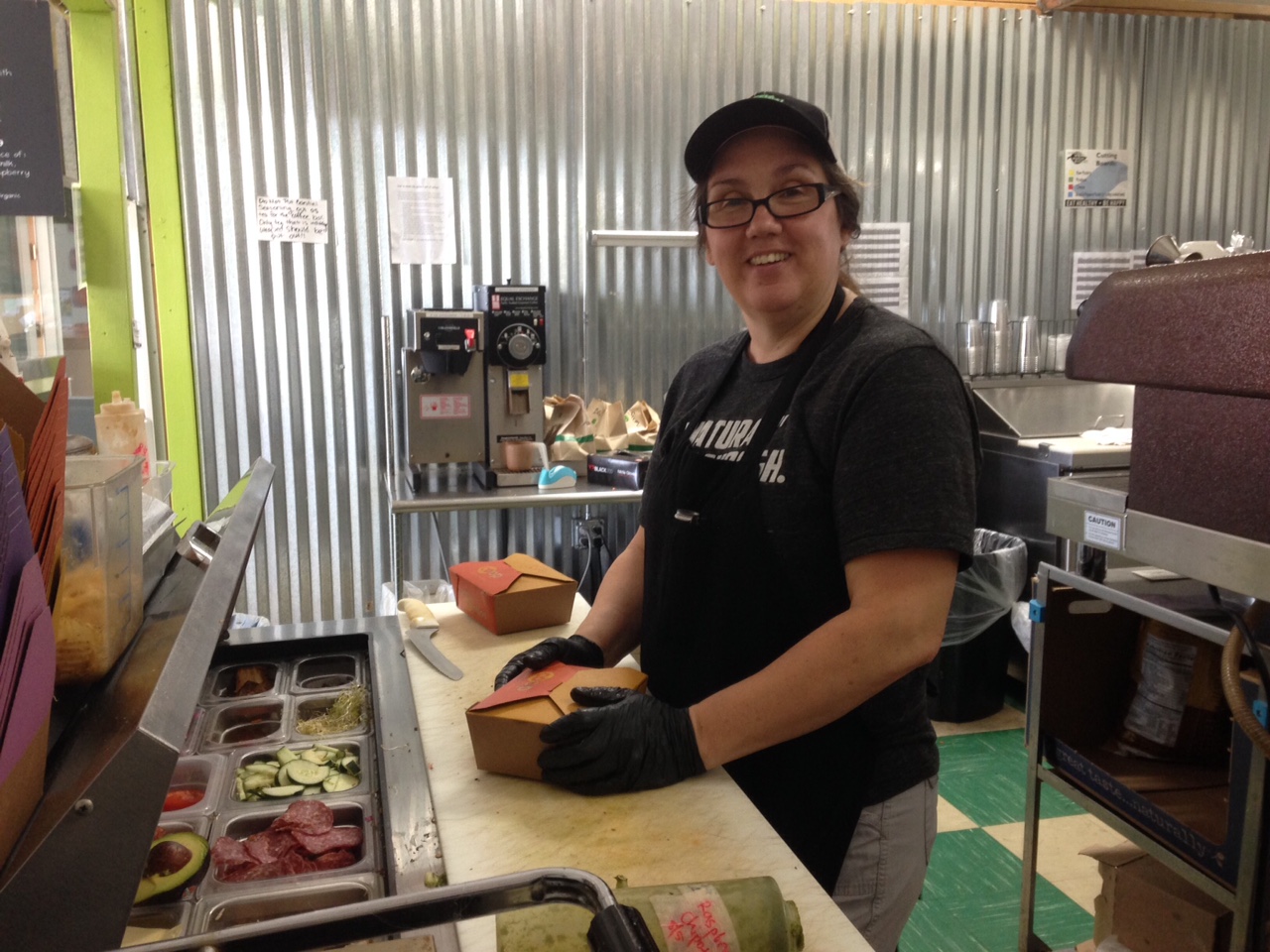 Lisa boxing up a made-to-order sandwich in the kitchen.