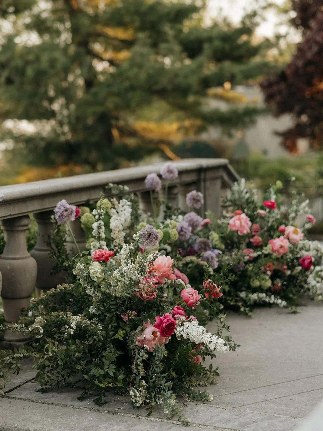 Romantic garden style floral installation designed by 1209 Creative at Villa Terrace Decorative Arts Museum in Milwaukee Wisconsin featuring lush pink, blush, and white wedding flowers for an outdoor ceremony