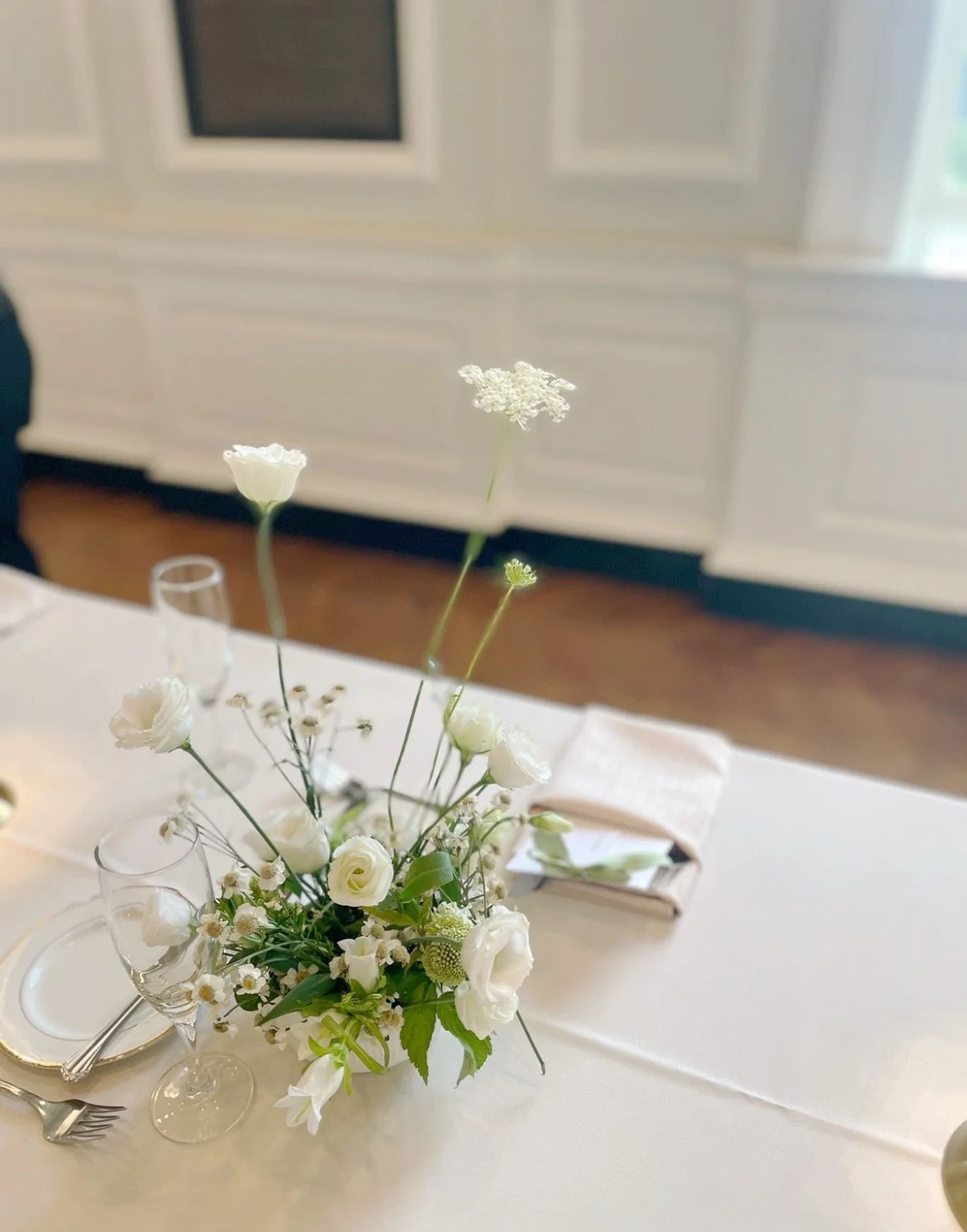 Small wedding table centerpiece with white florals designed by 1209 Creative at the Chicago History Museum, featuring an elegant editorial wedding style in a historic Chicago venue