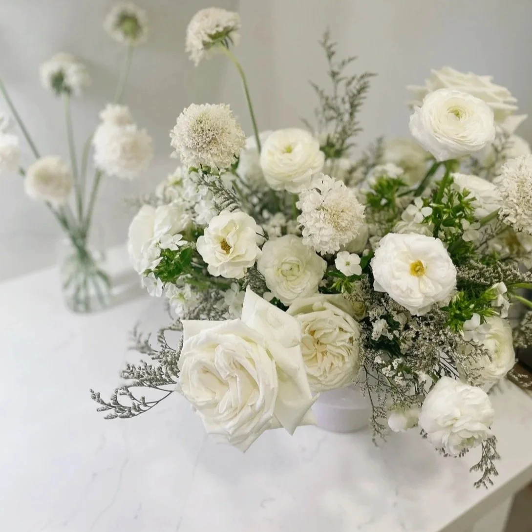 White wedding floral centerpiece featuring garden roses, ranunculus, and soft greenery, designed by 1209 Creative for a modern, elegant wedding for a Desert Mountain Golf Club wedding in Scottsdale, Arizona.